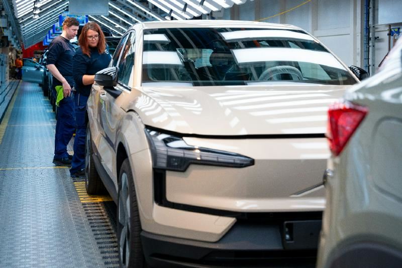 A group of people standing next to a car
AI-generated content may be incorrect.