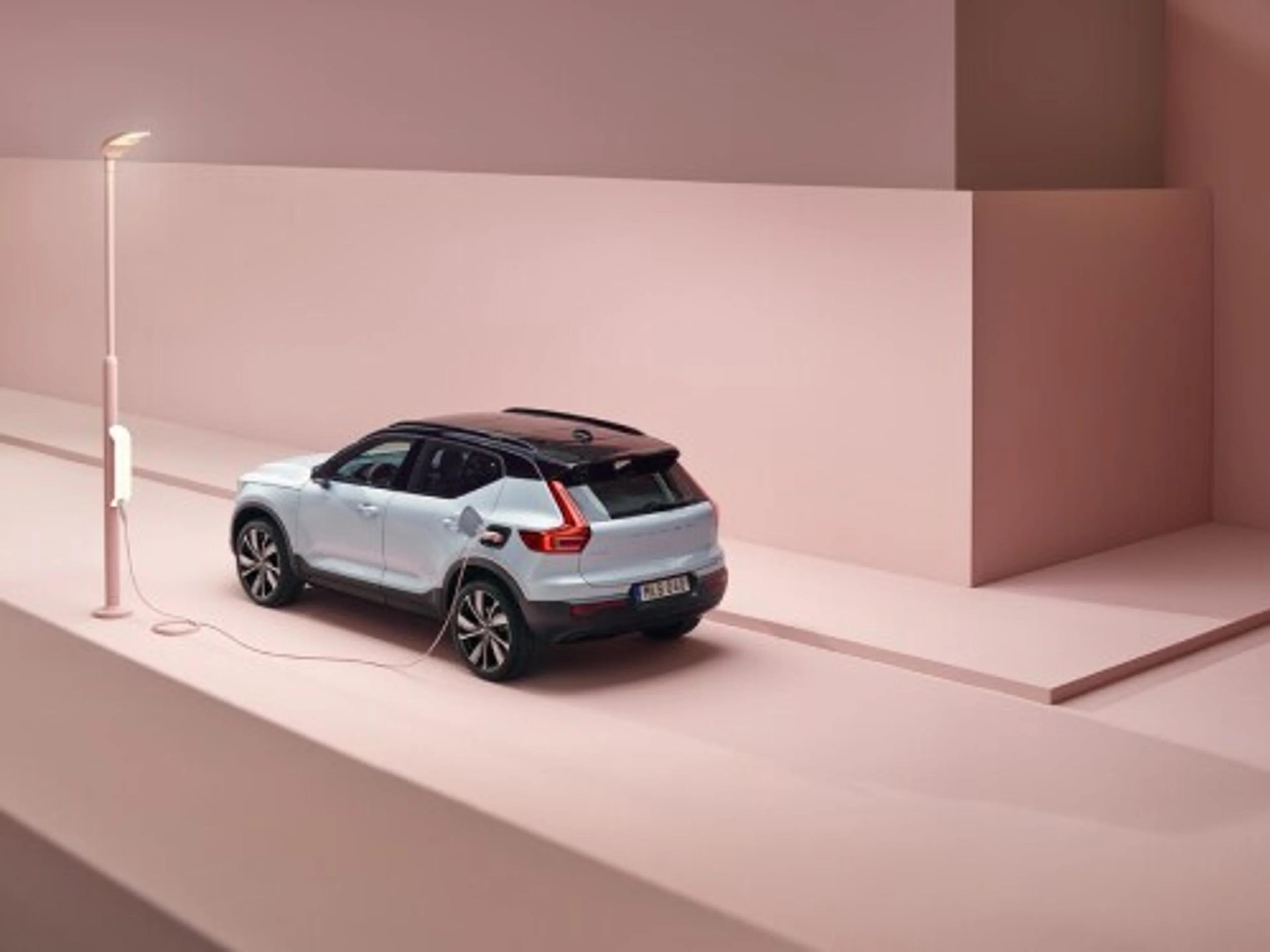 Volvo XC40 Recharge รถยนต์ electric SUV ขณะเสียบสายชาร์จกับตู้ชาร์จไฟที่ติดตั้งอยู่บนเสาไฟฟ้า