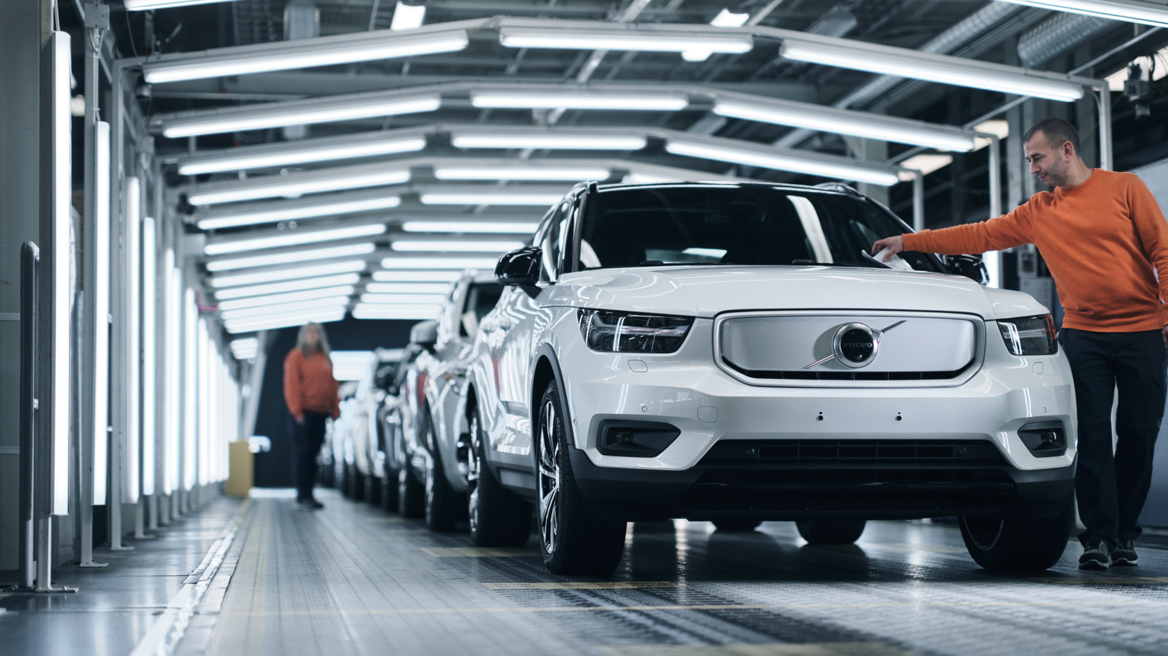 一個孩子坐在停著的汽車後方