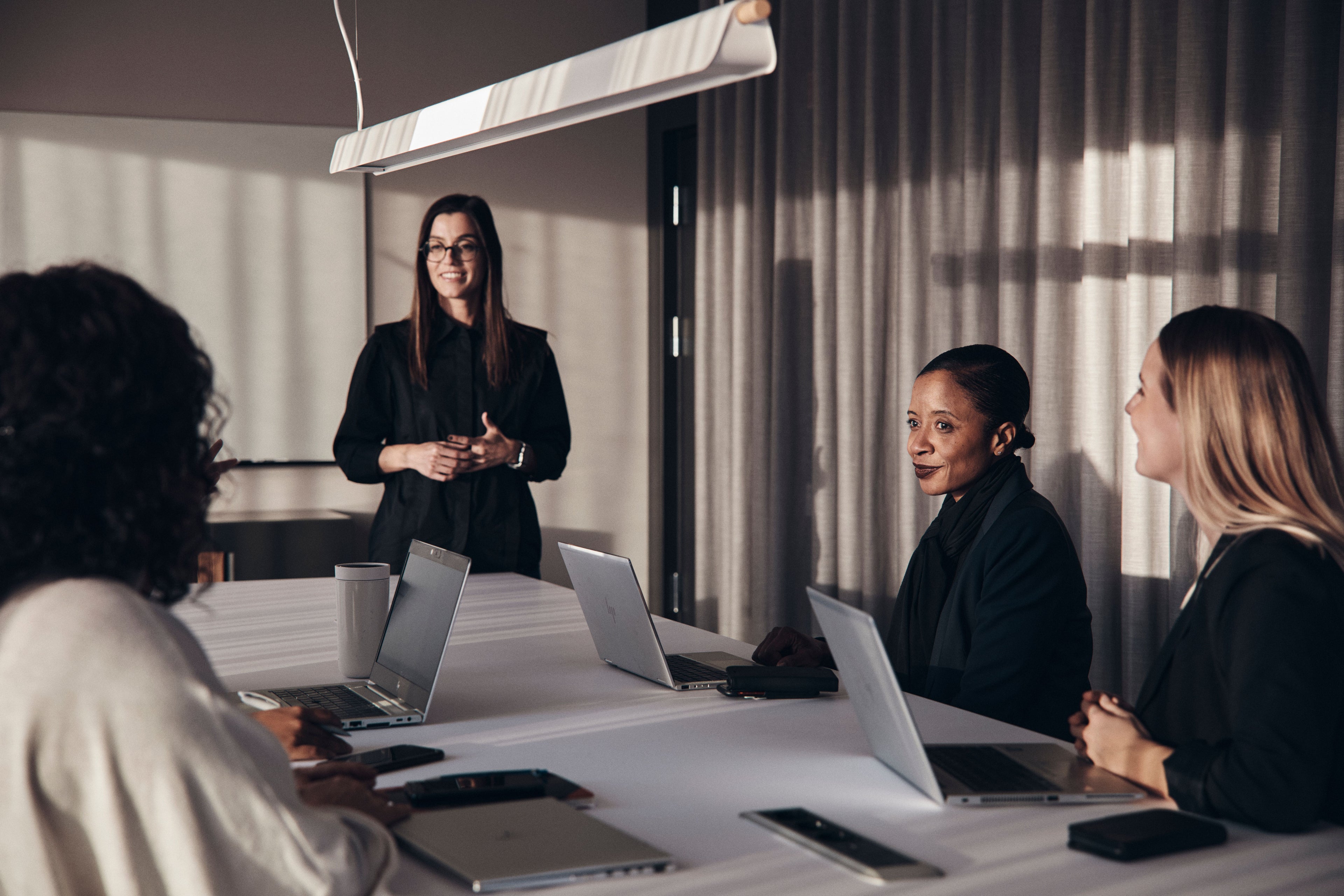 A woman making a presentation in an enclosed office.