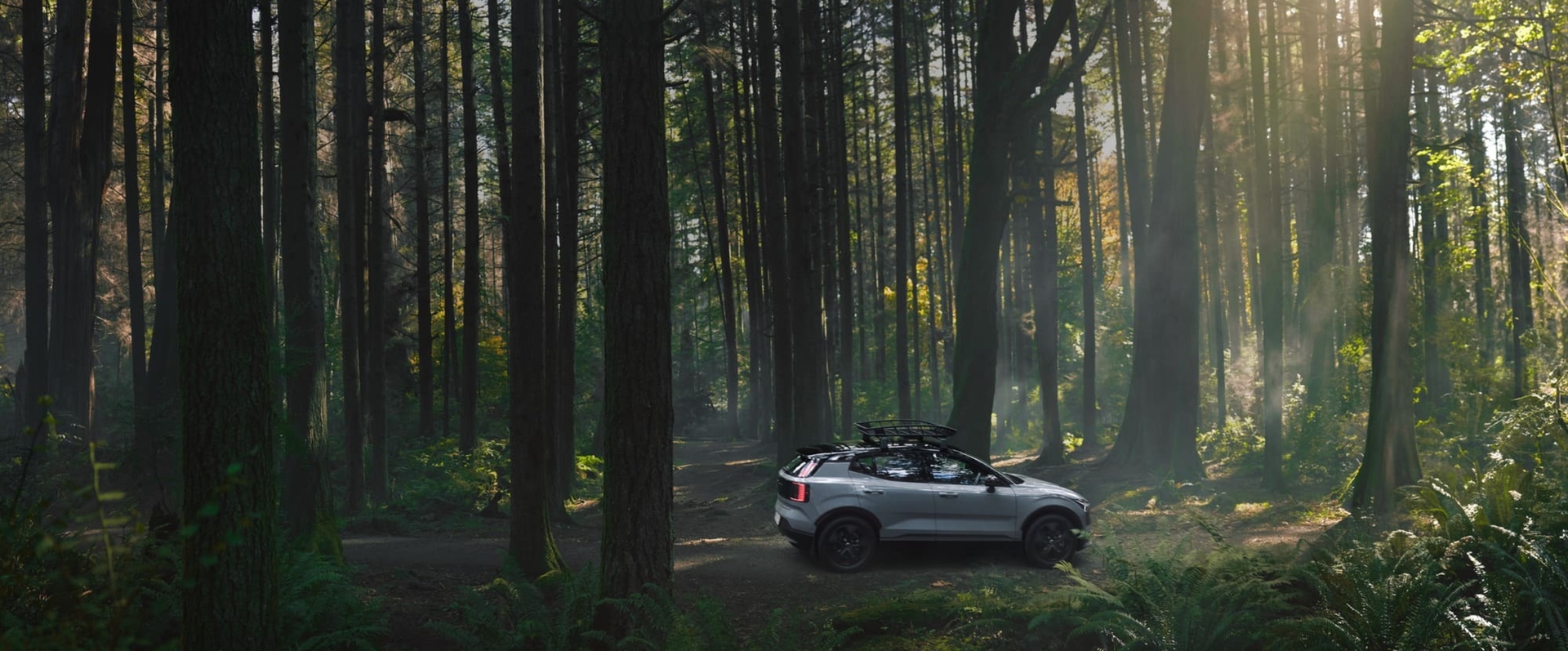 A family at the beach near a Volvo XC90 Plug-in hybrid, changing from skiing clothes to swimming clothes.