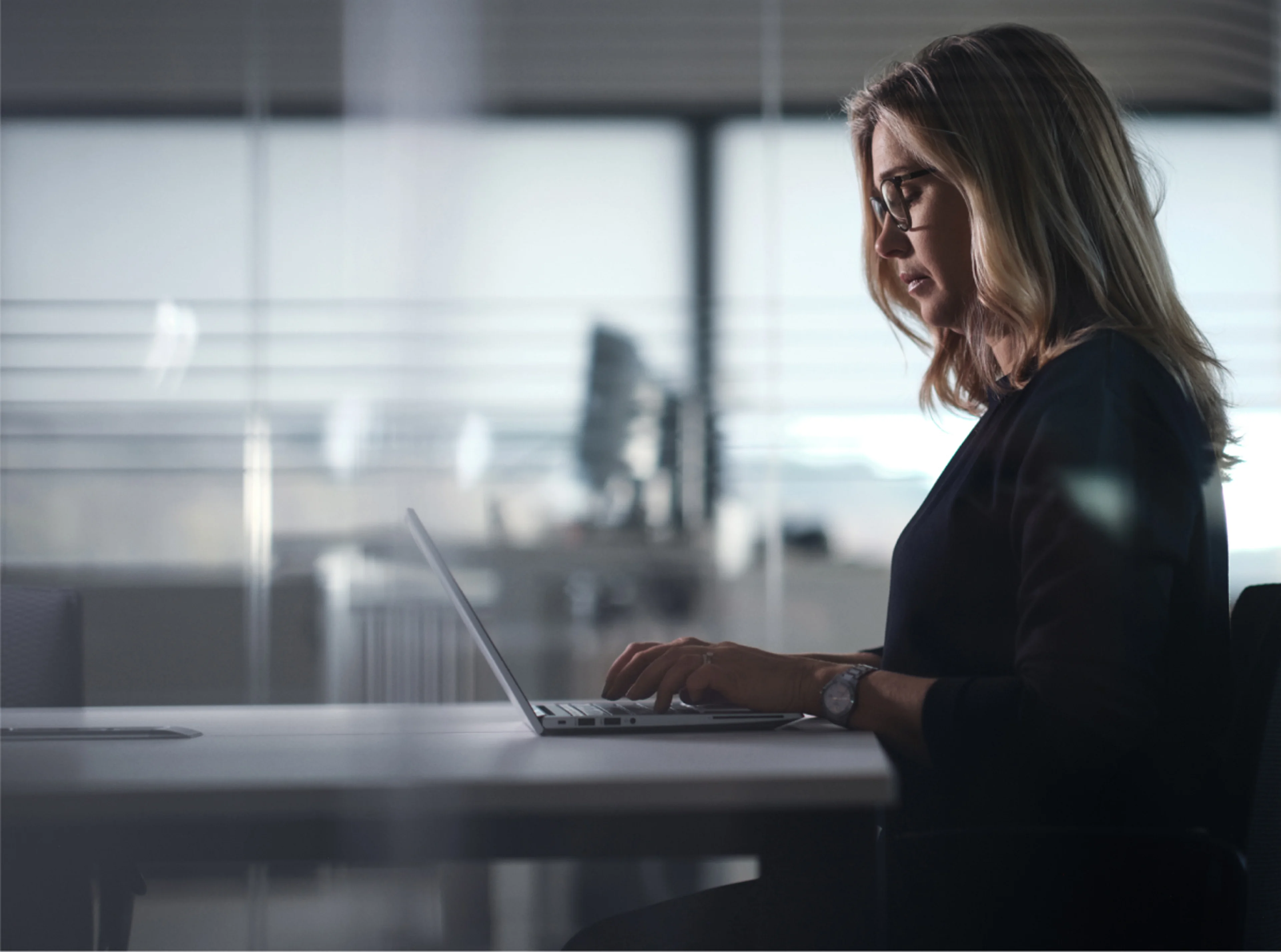 Seitenansicht einer Frau, die am Laptop arbeitet.