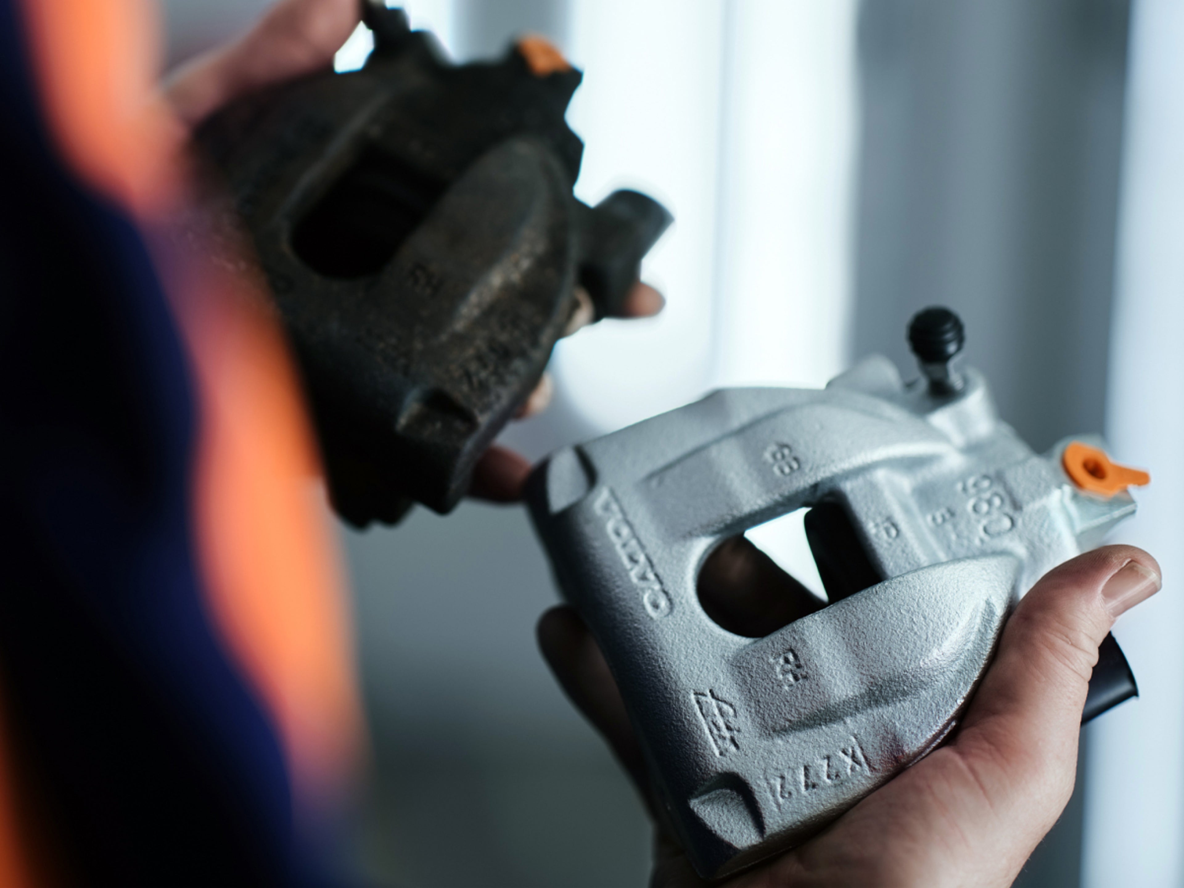 Gros plan sur une personne tenant une pièce détachée Volvo.