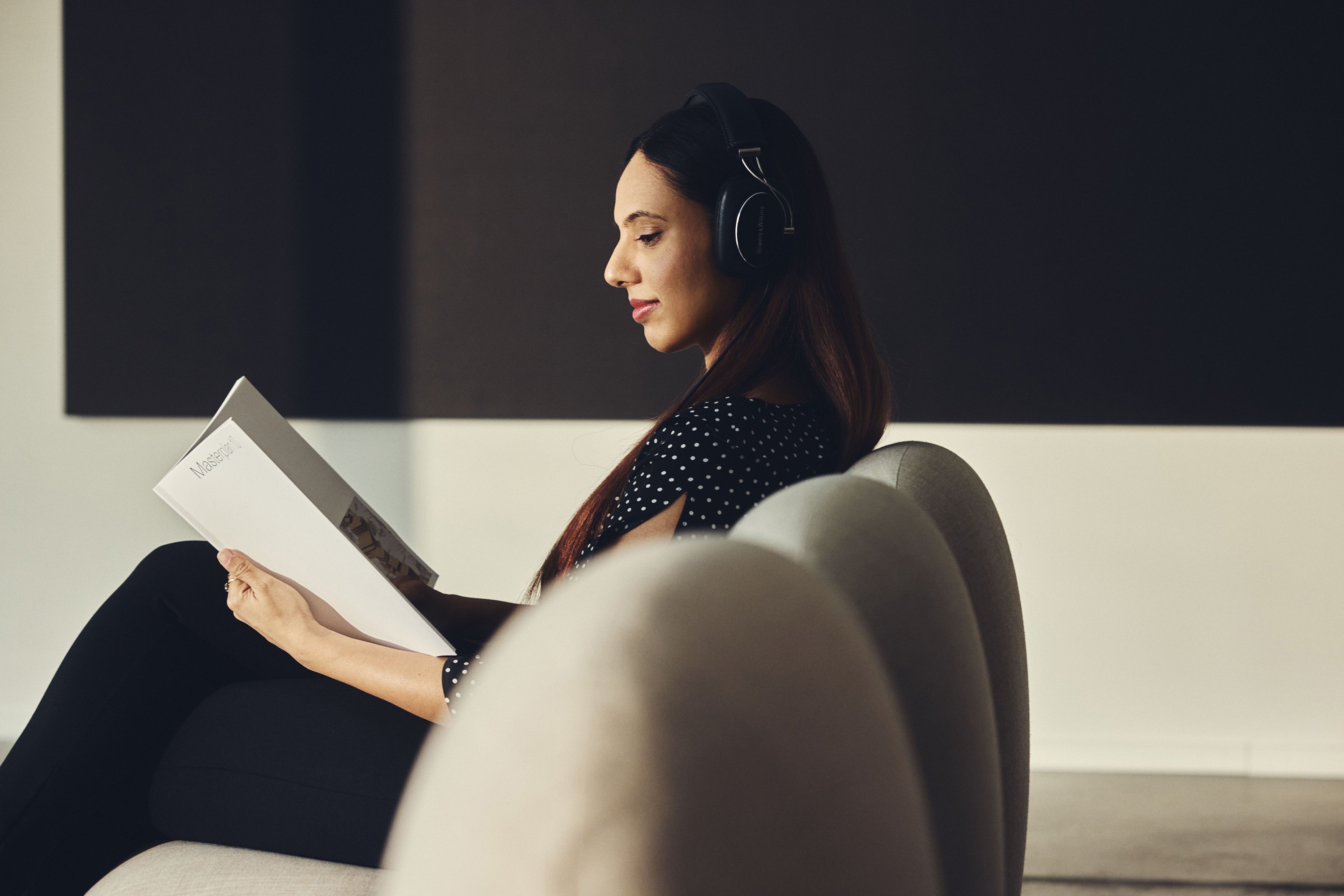 Woman reading and sitting in chair.
