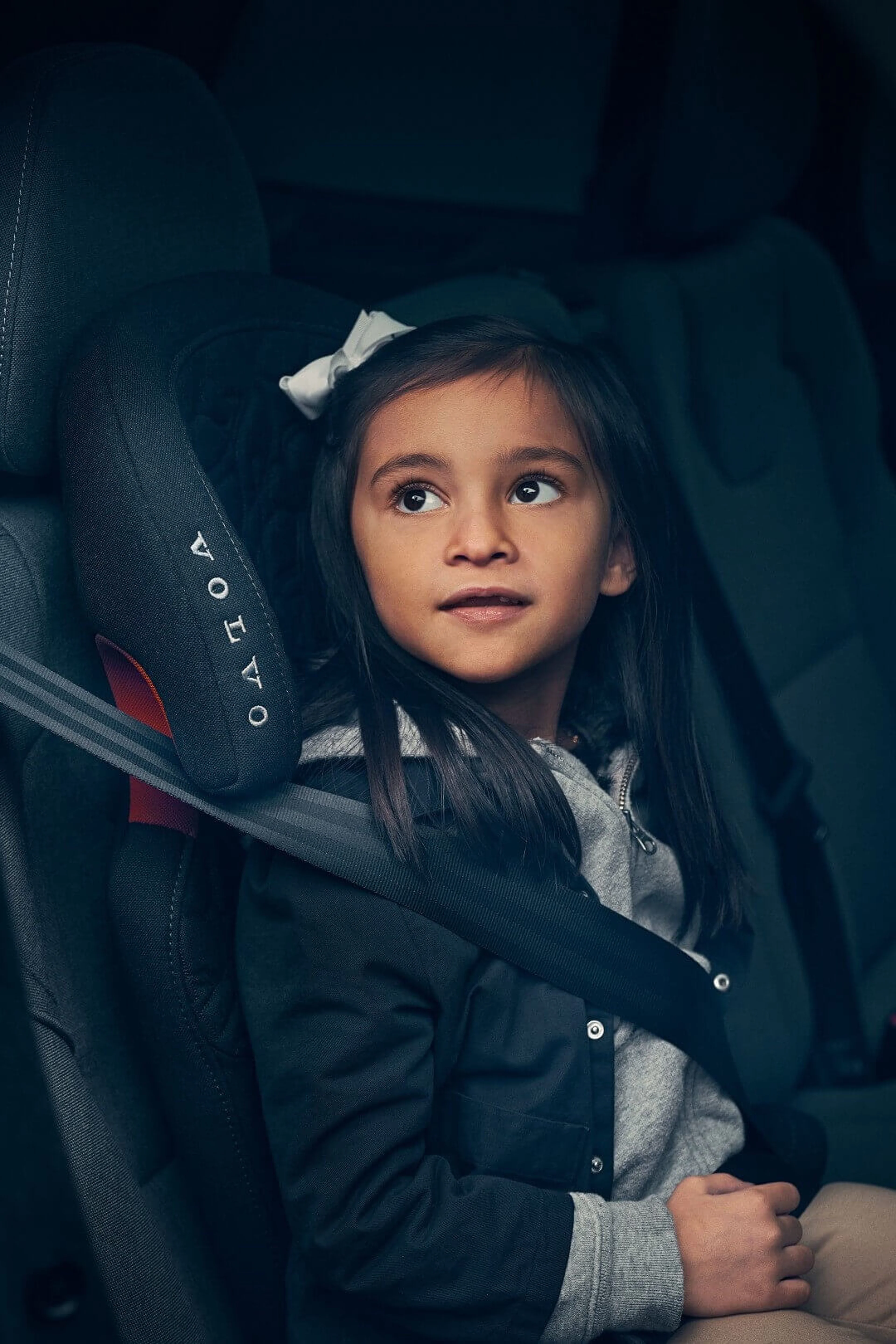 A child sitting in a Volvo child seat looking outside