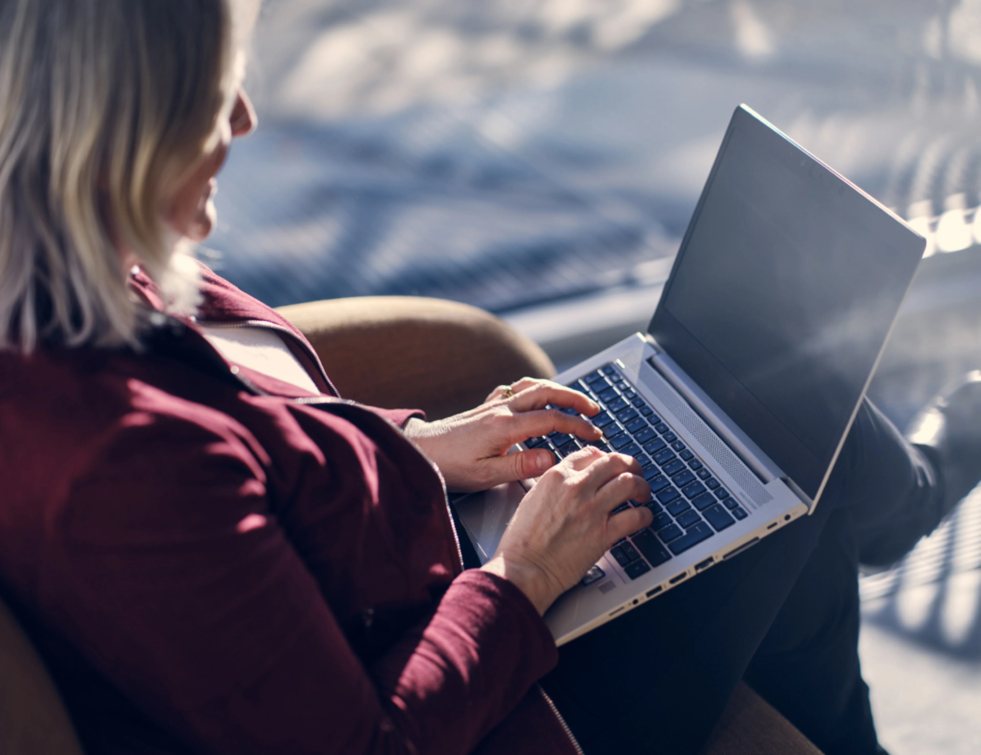 Seitenansicht einer Frau, die am Laptop arbeitet.