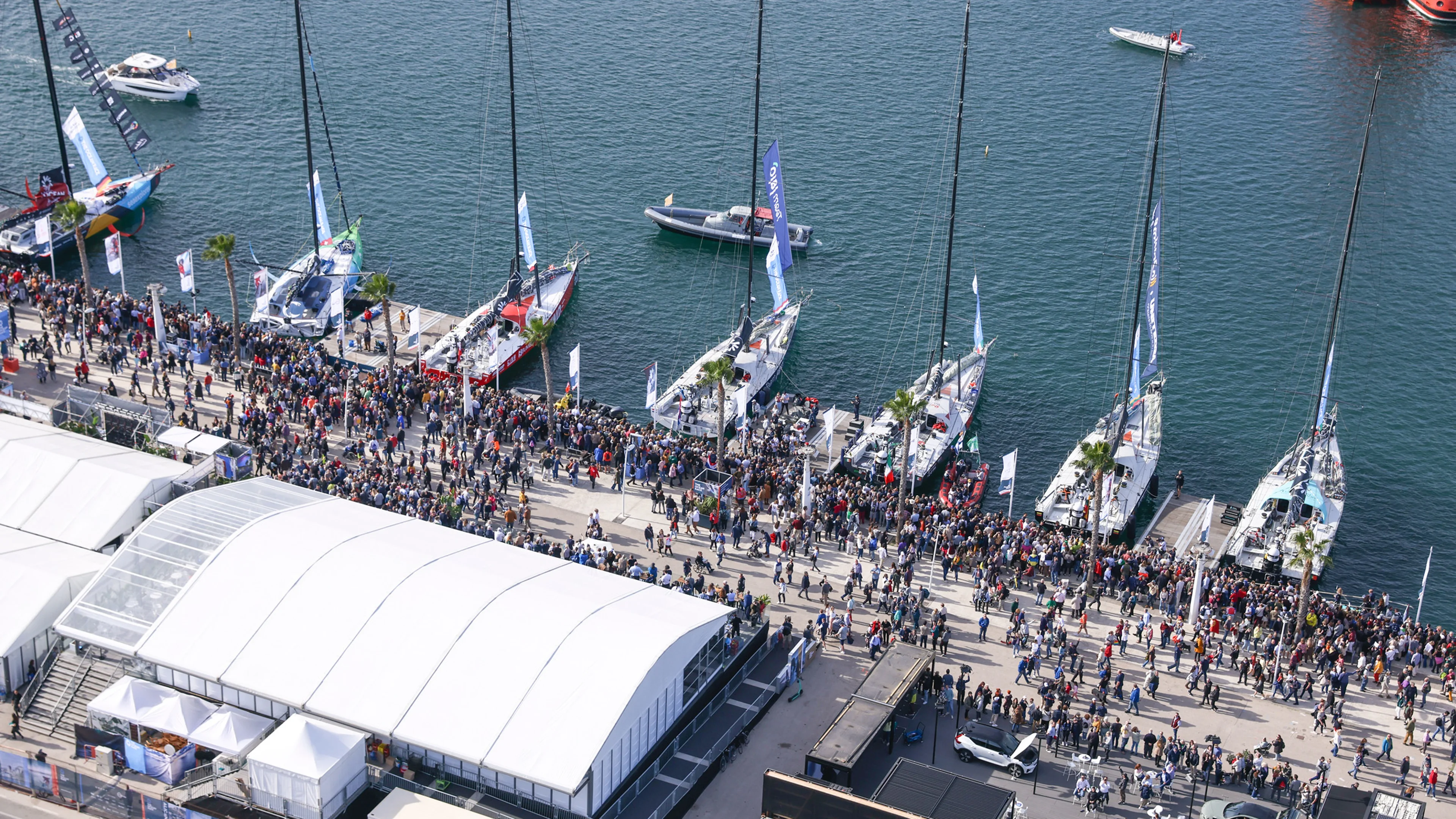 Mase se okupljaju duž marine ispunjene jedrilicama The Ocean Race-a, slaveći ovaj događaj.