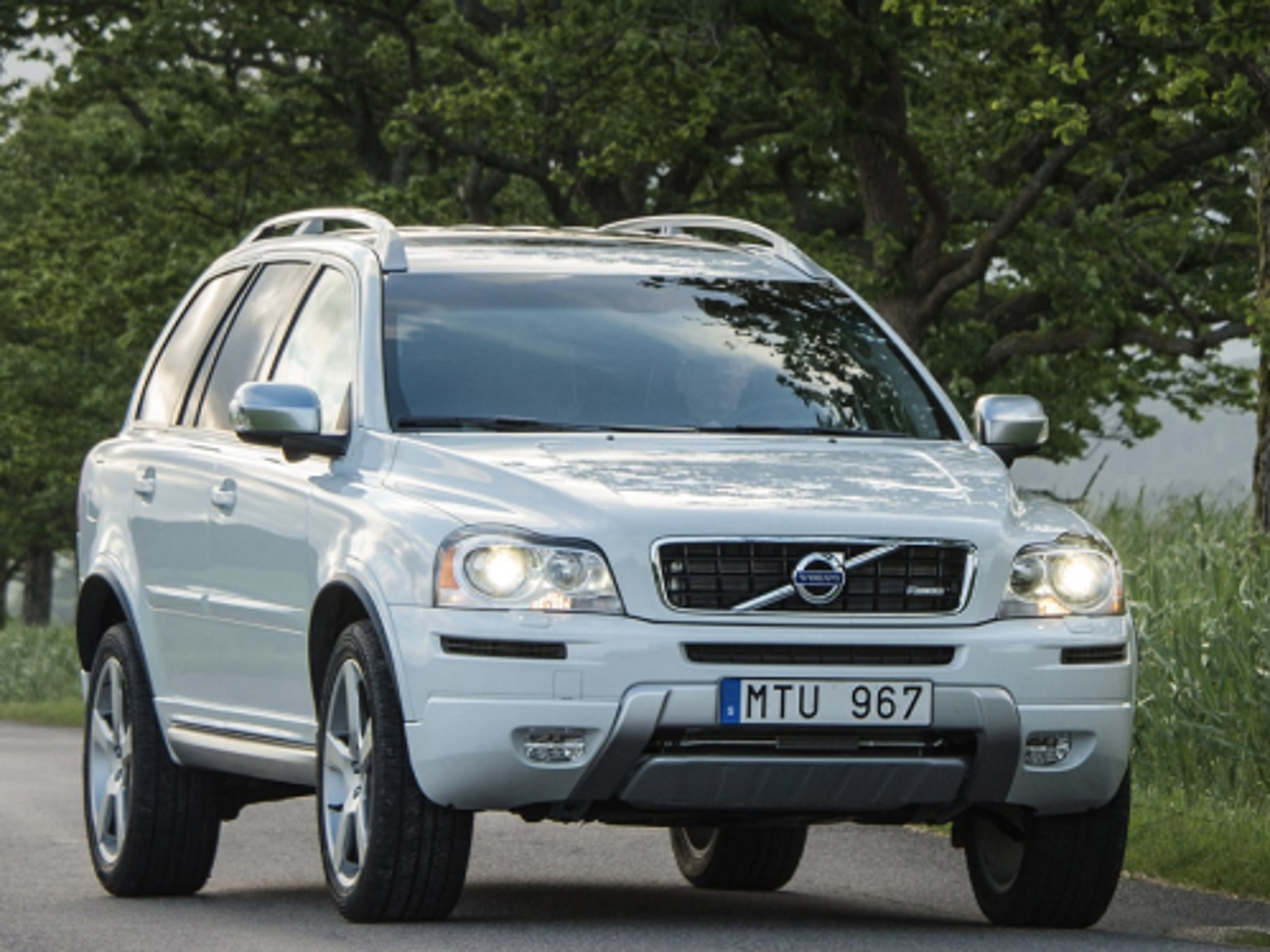 A grey Volvo XC90 driving on a country road.