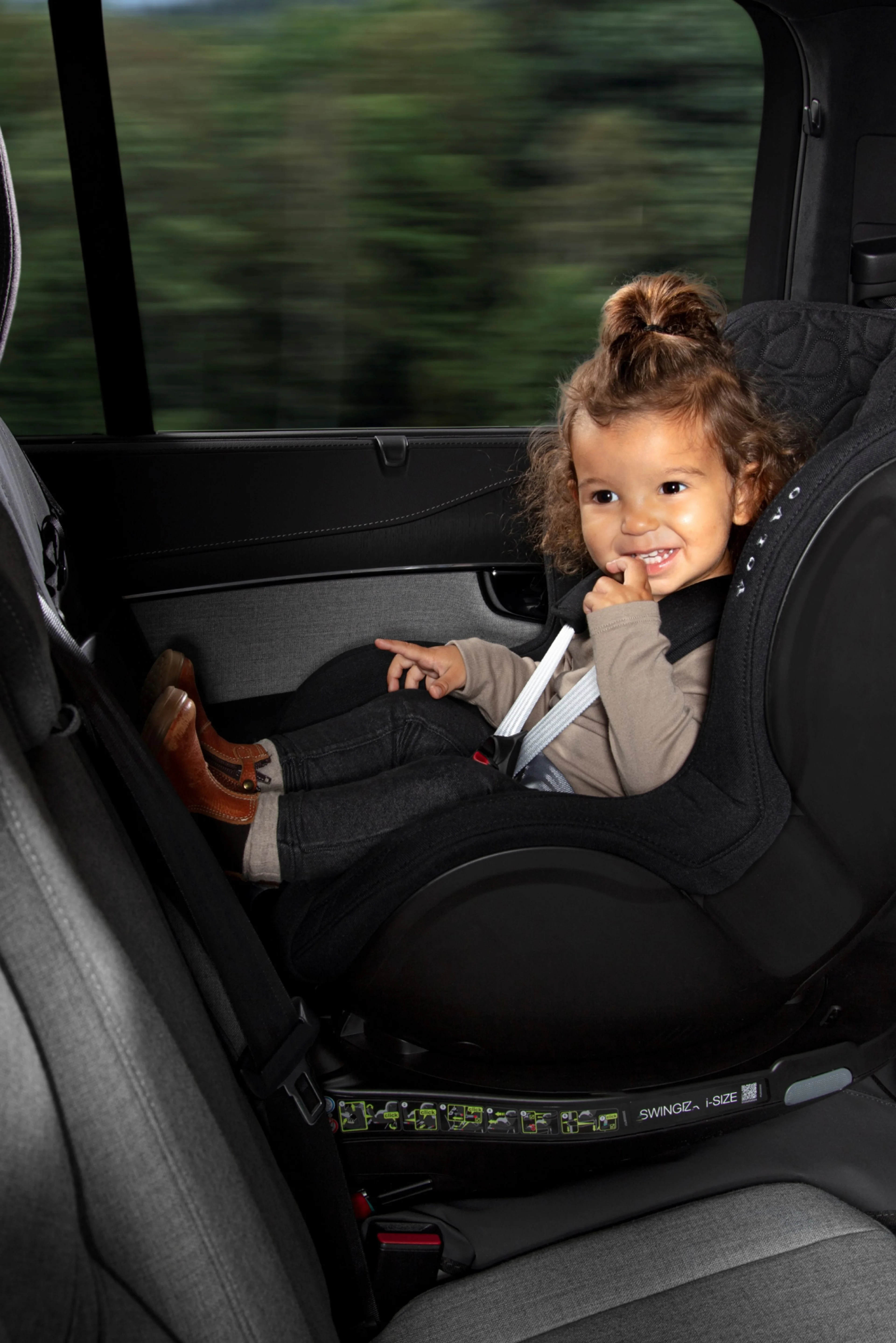 Un niño en un asiento de vehículo sonriendo