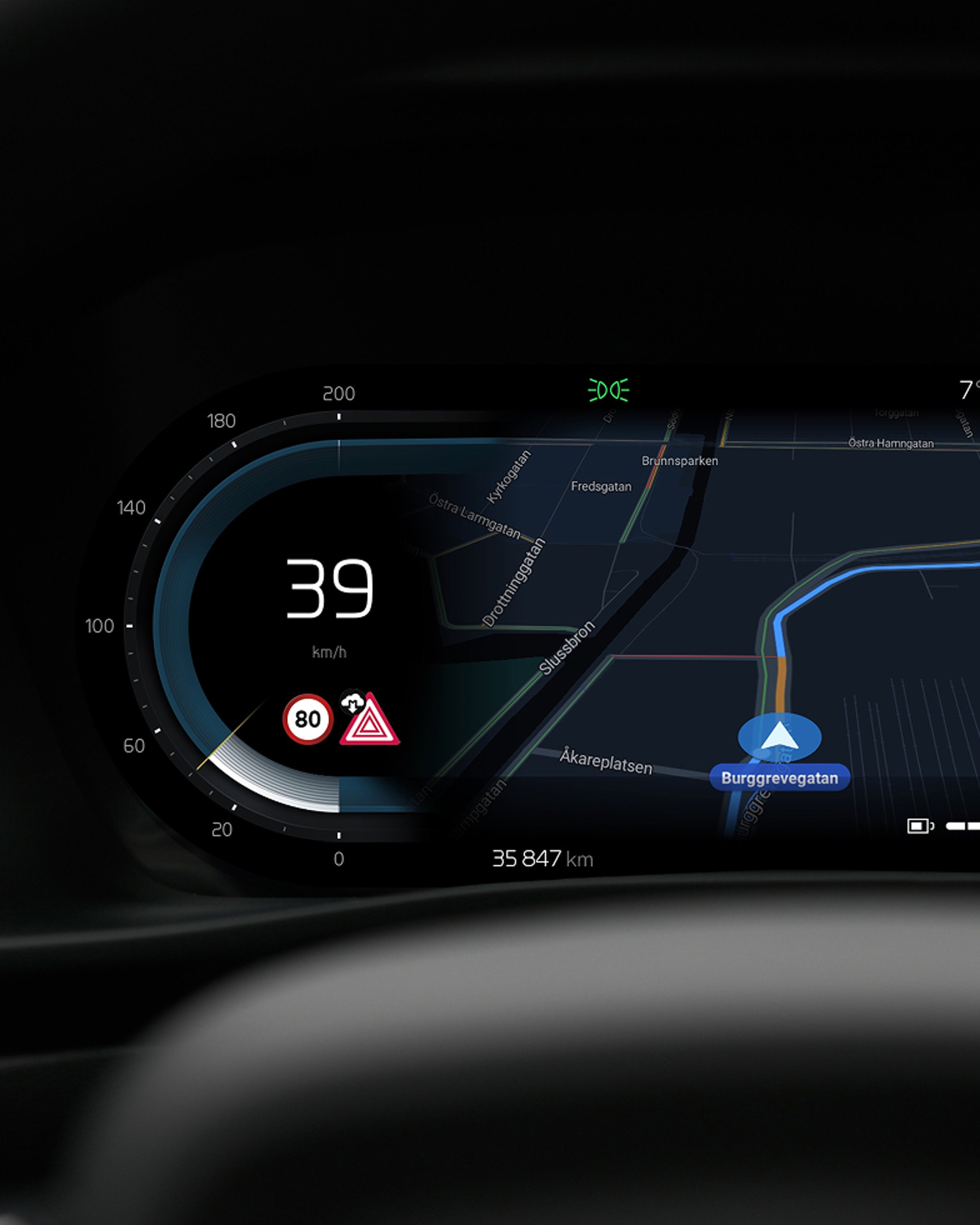 Close-up view of a dashboard in a Volvo car, displaying an in-car navigation system with a highlighted route and the current speed.