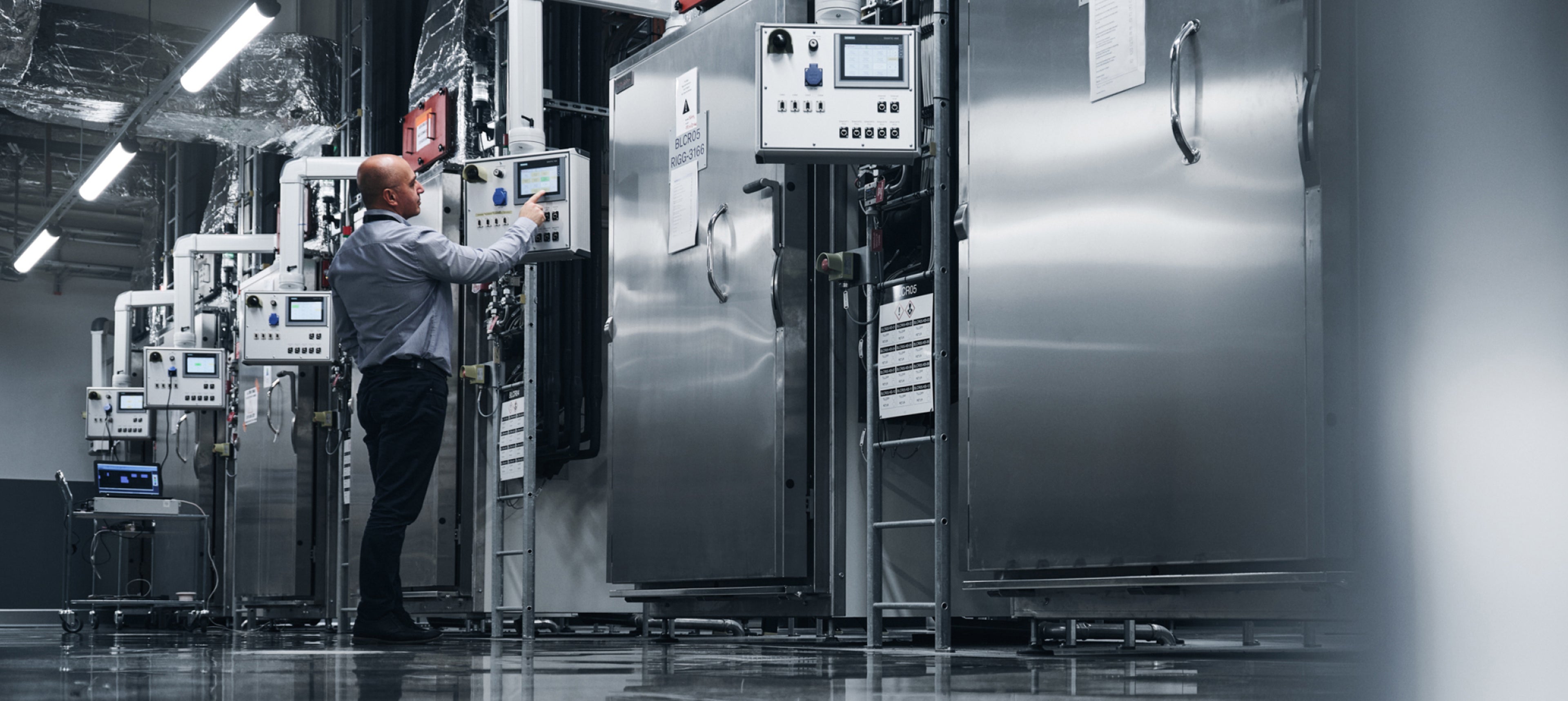 在製造工廠內操作某個系統的男子。