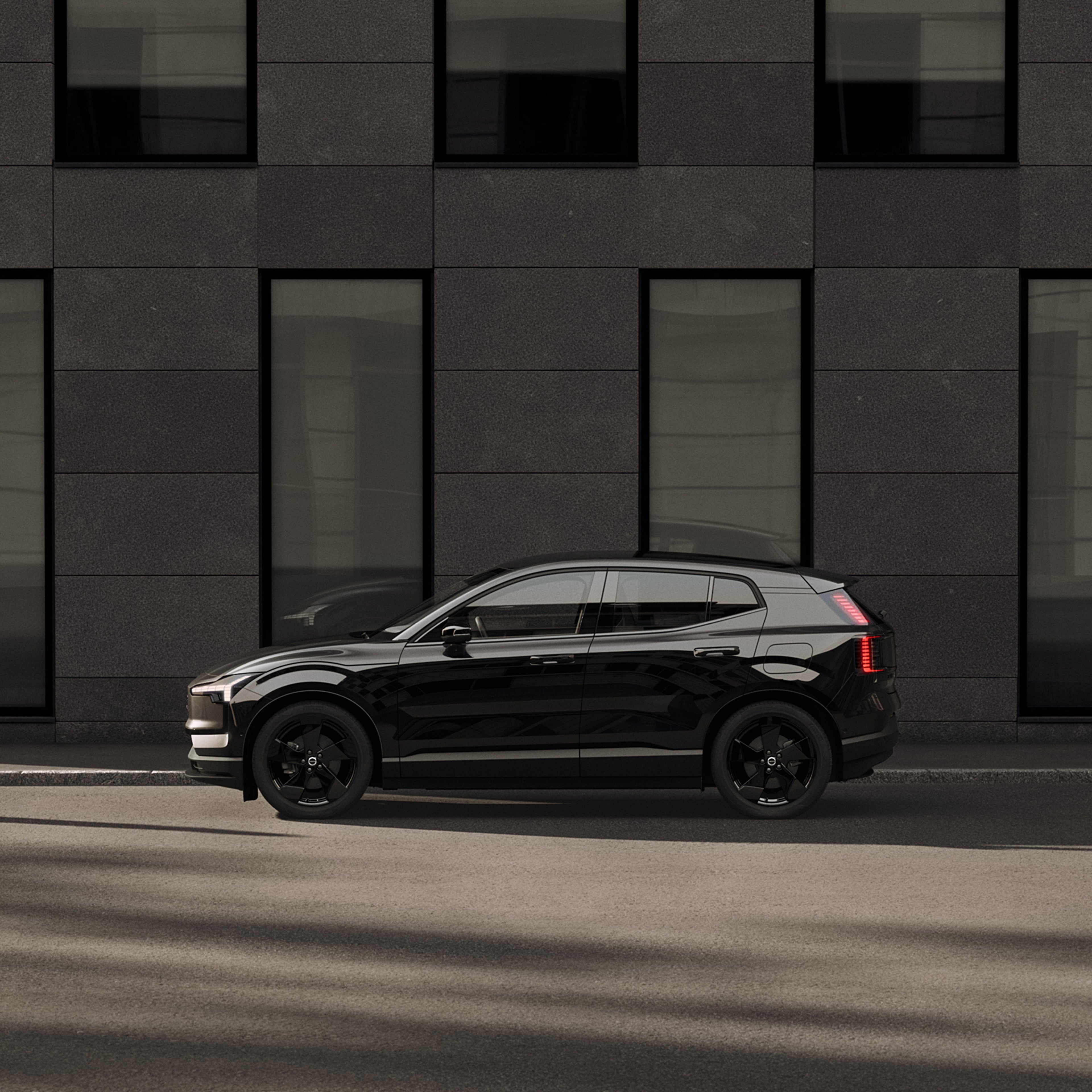 Vue latérale de la Volvo EX30 Black Edition montrant la silhouette et les jantes noires.
