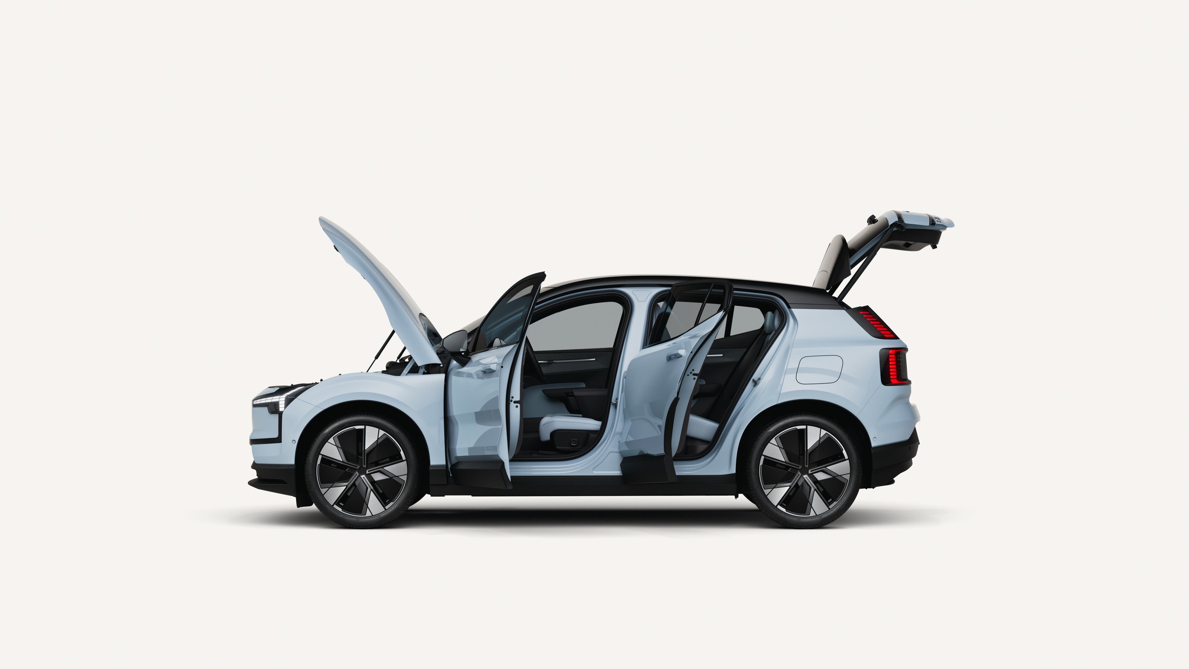 Side view of the Volvo EX30 electric with open hood, doors, and trunk in a white studio environment.
