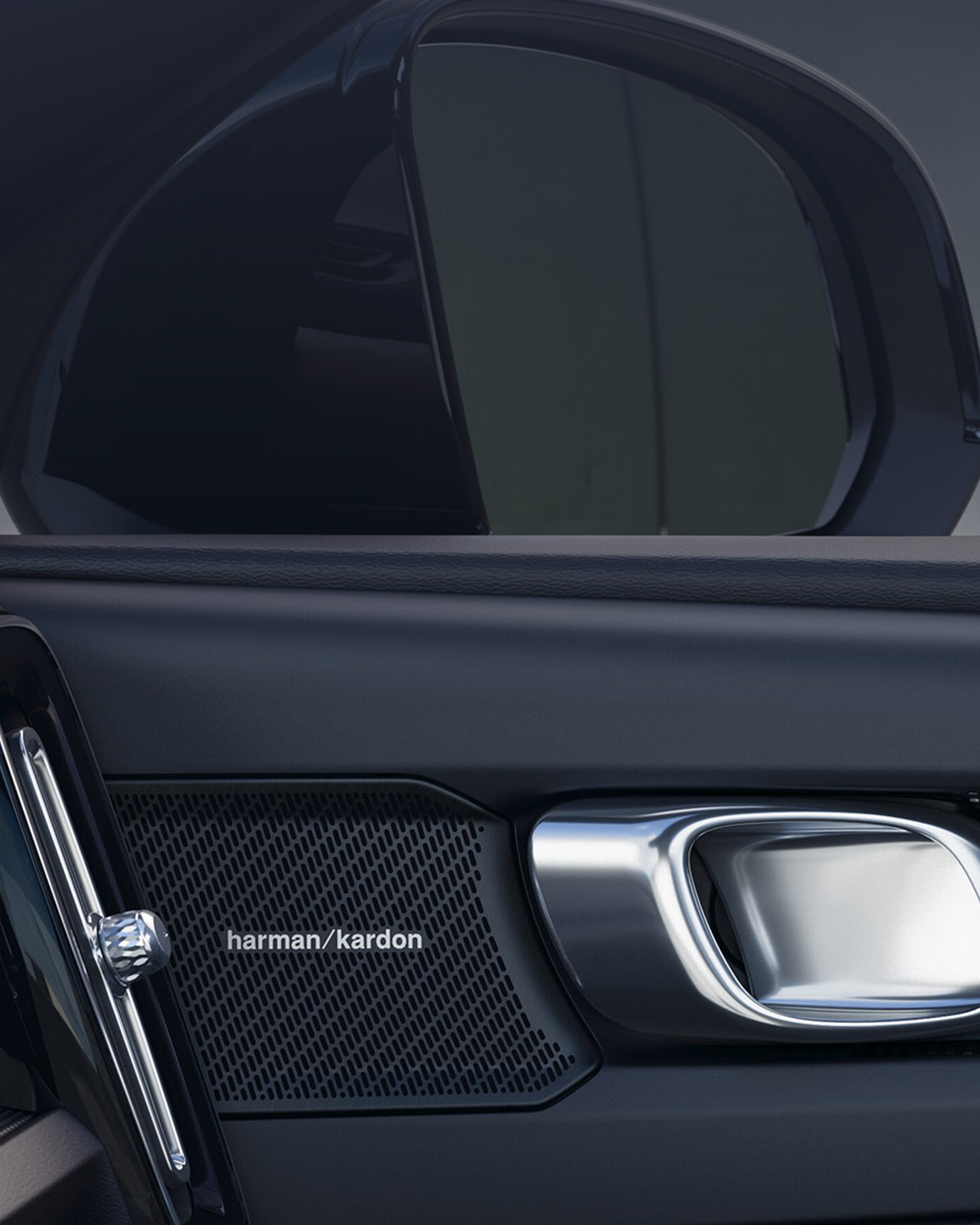 Yksityiskohta Volvo EX40 täyssähköauton matkustajan puoleisen etuoven sisäverhoilusta ja Harman/Kardon kaiuttimesta.