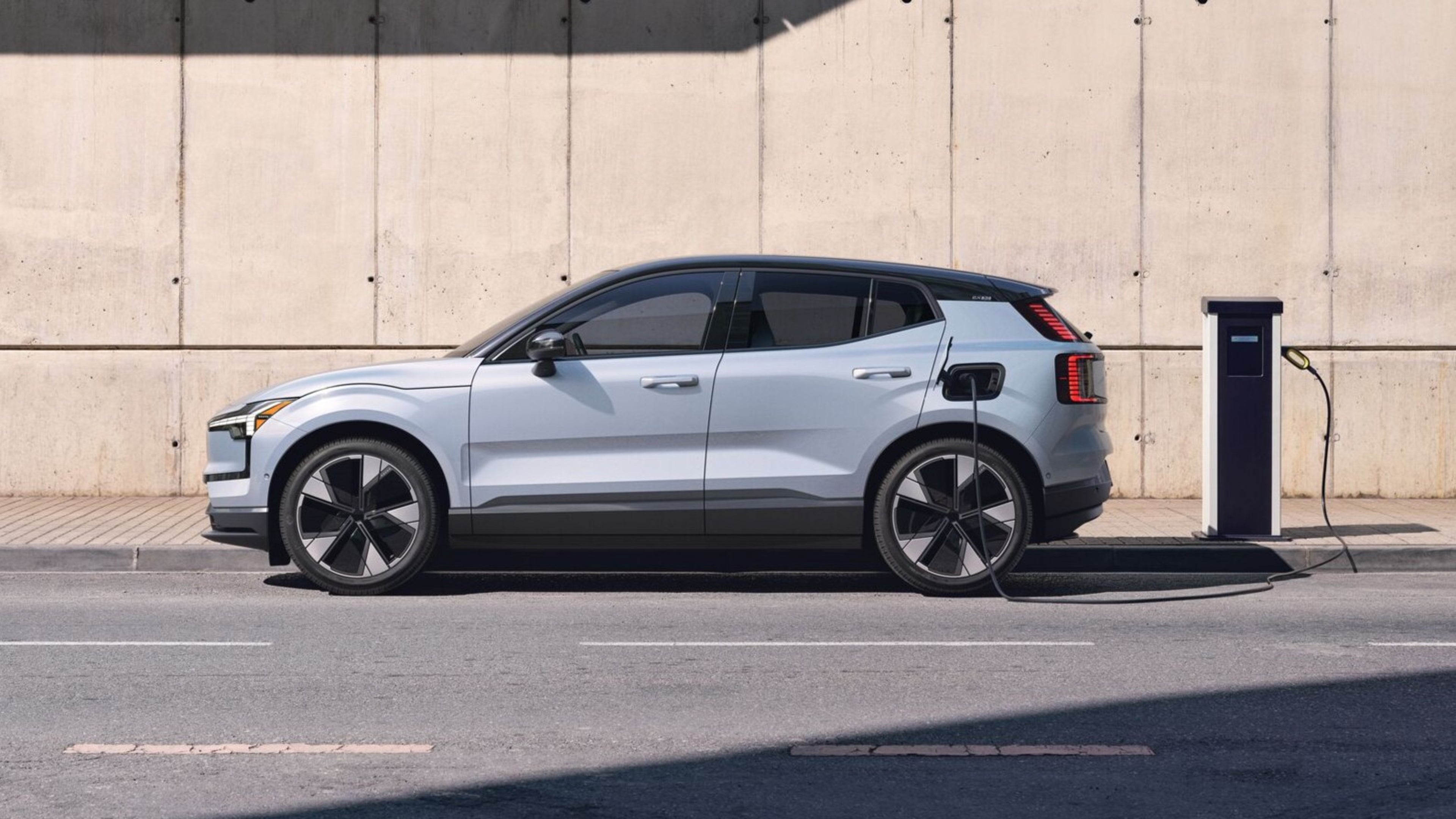 A Volvo EX30 parked next to a charging station
