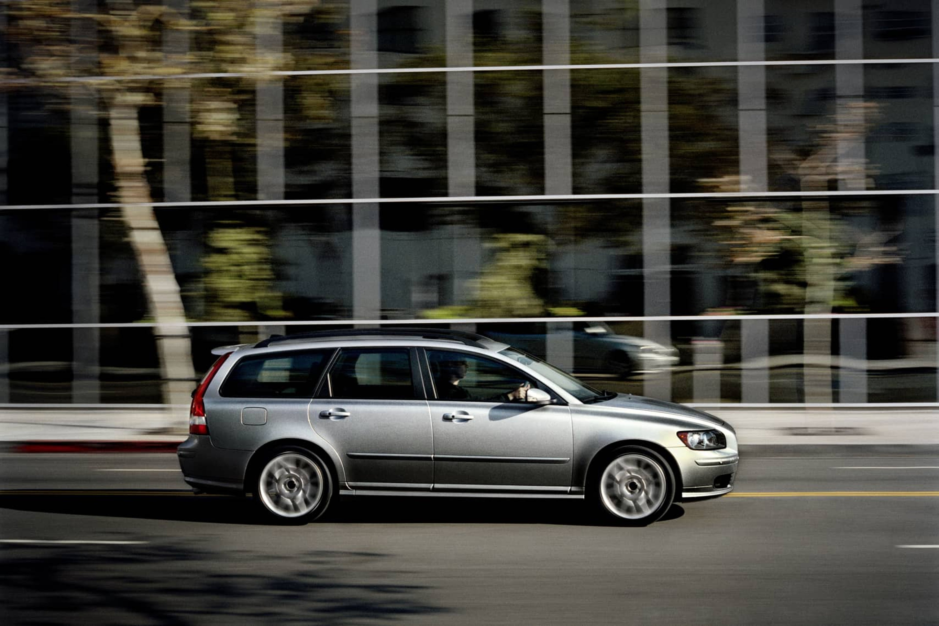 Una imagen del lateral de un Volvo V50 gris circulando por un entorno urbano.