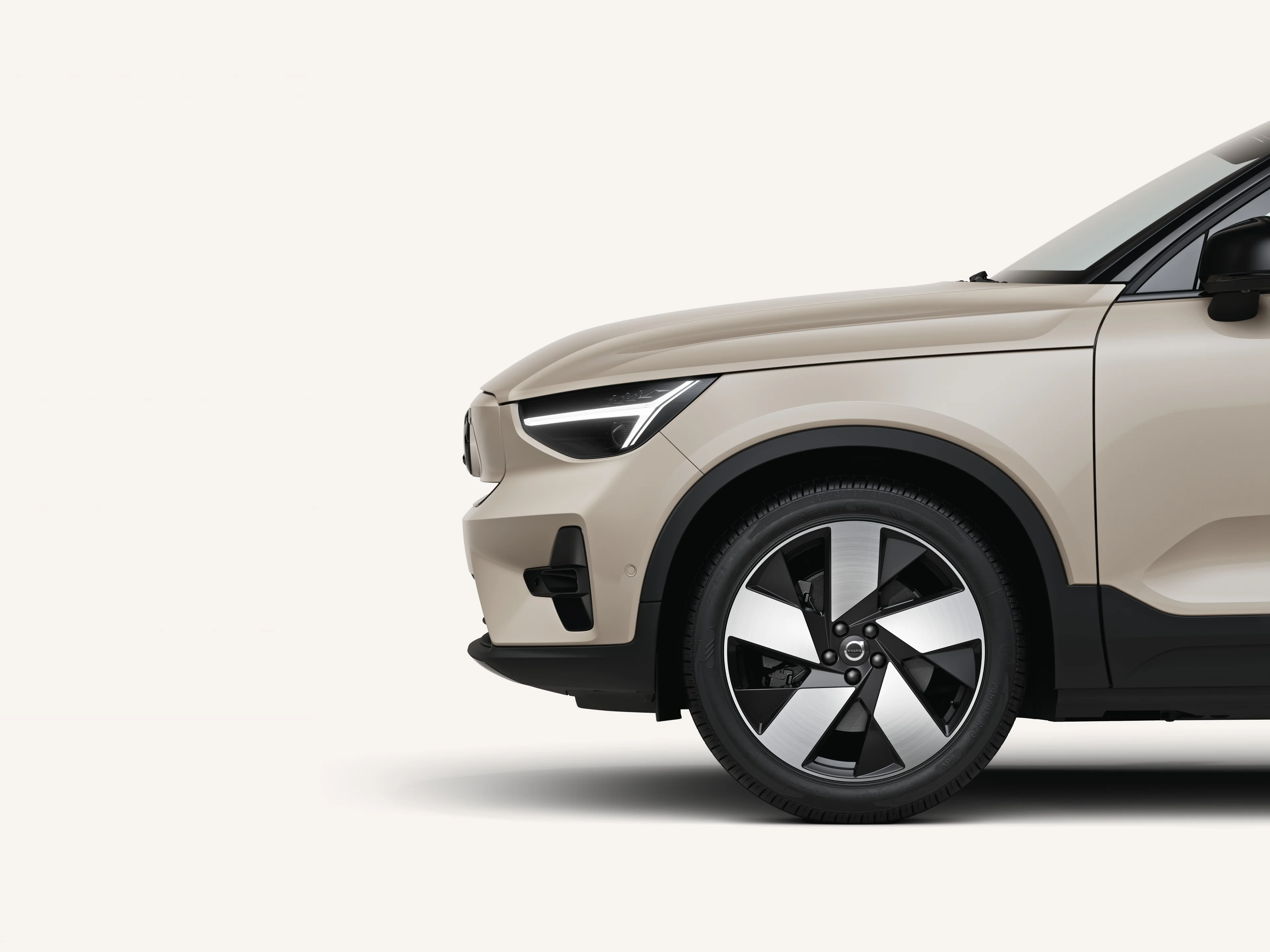 Front half of the Volvo EX40 in a white studio environment.