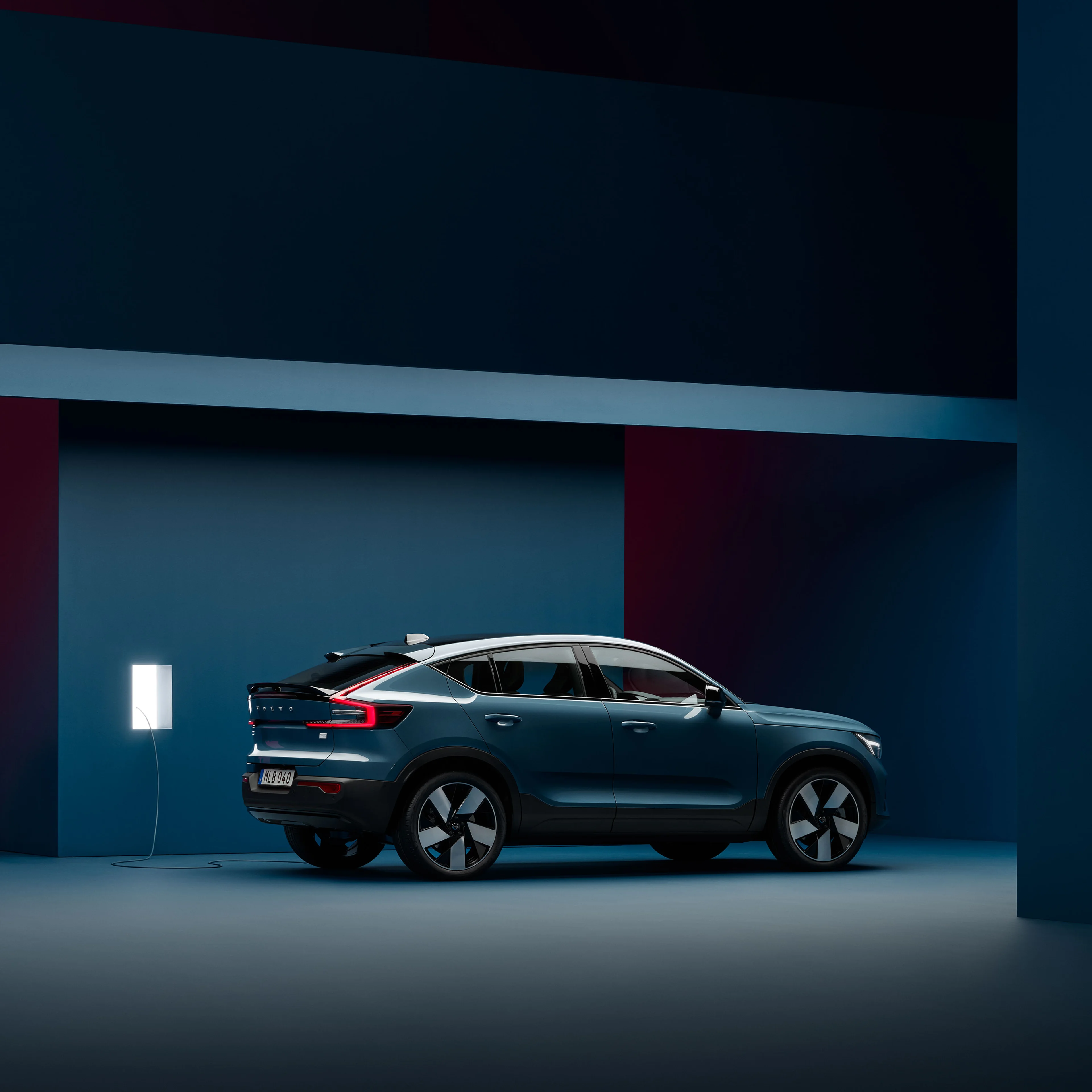 充電ステーションで充電ケーブルを接続されたボルボXC40 Rechargeのフロントデザイン。