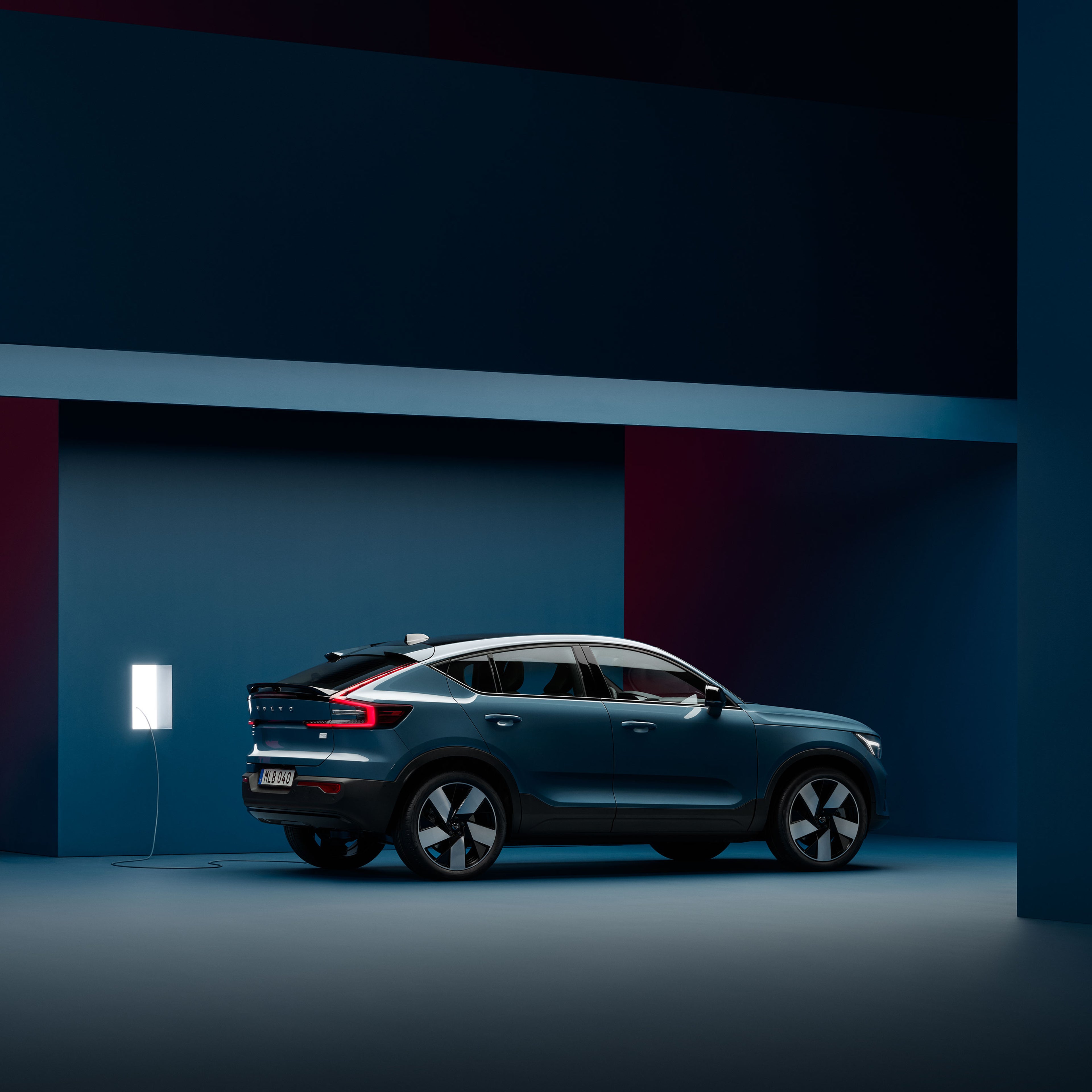 充電ステーションで充電ケーブルを接続されたボルボXC40 Rechargeのフロントデザイン。