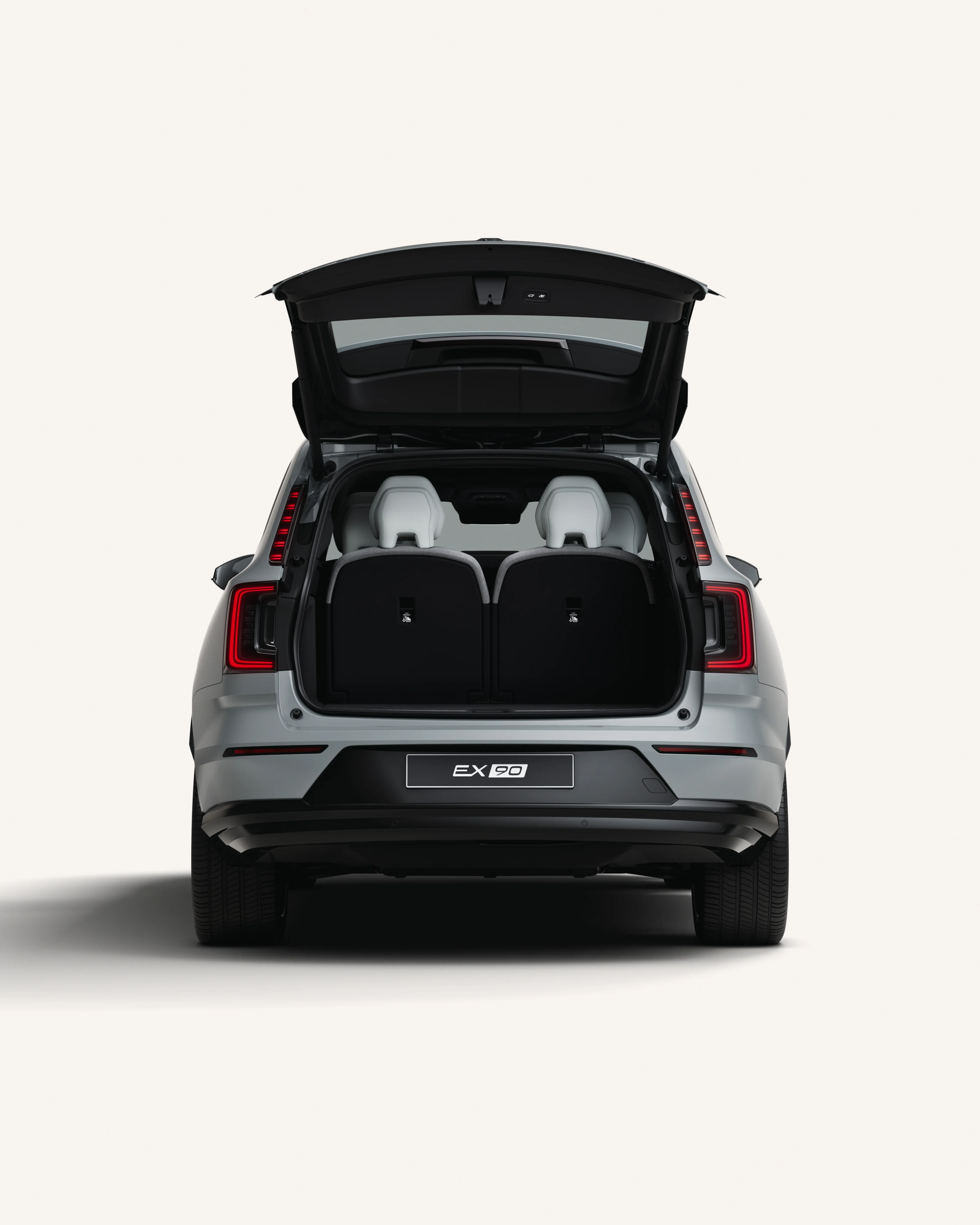 Volvo EX90 sedd bakifrån med öppet bagageutrymme i en vit studiomiljö.