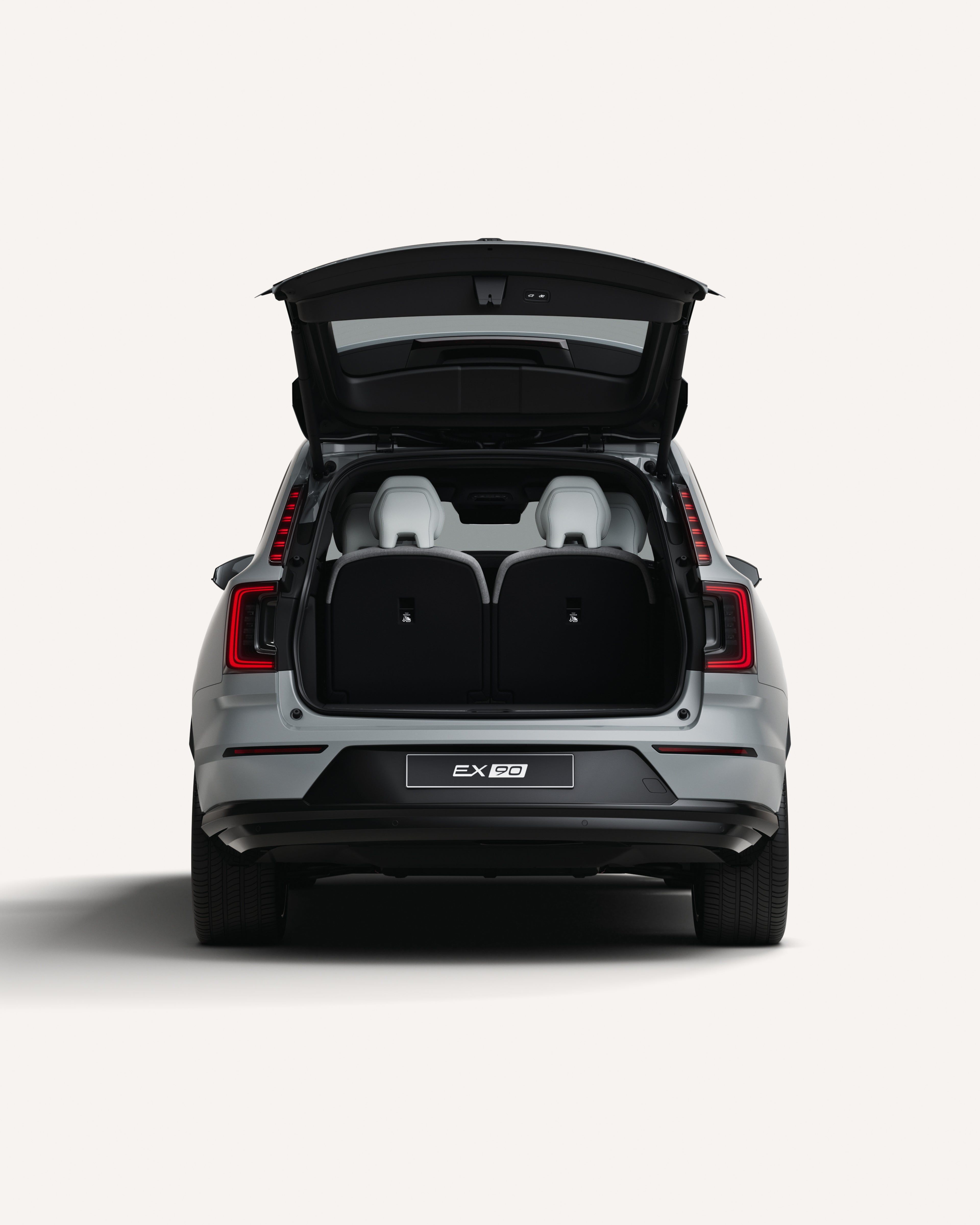 Vue arrière de la Volvo EX90 avec le coffre ouvert dans un studio blanc.