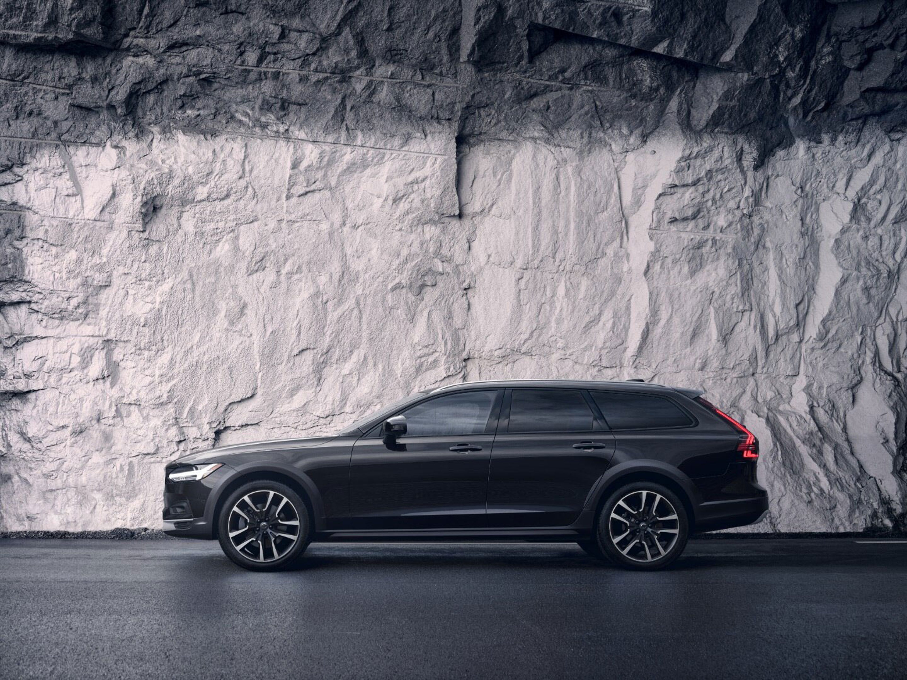 A grey Volvo V90 Cross Country standing in front of an artistic wall.