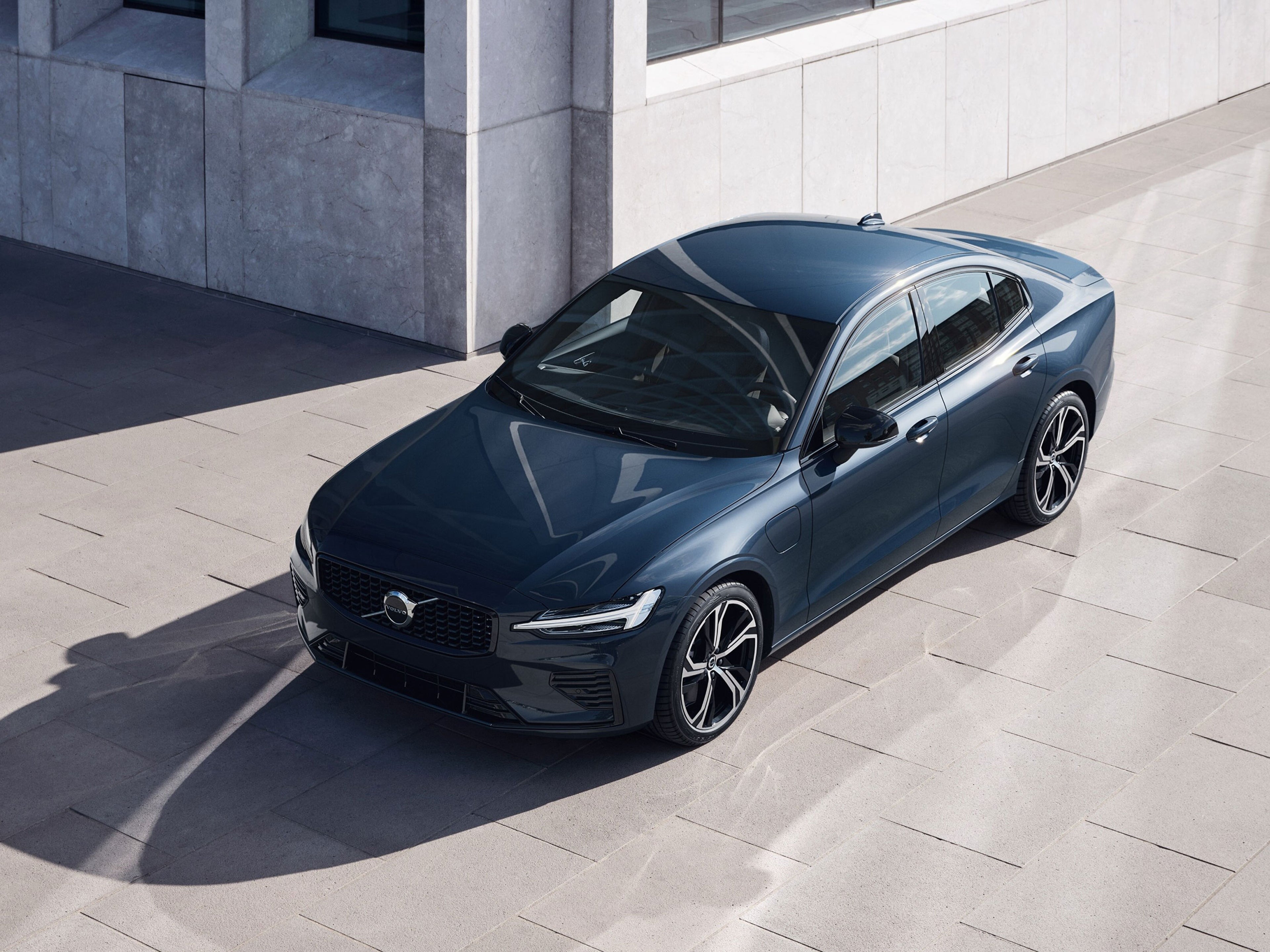 Tummansininen Volvo S60 Recharge Long Range Sport Edition lataushybridi etuyläviistosta kuvattuna.