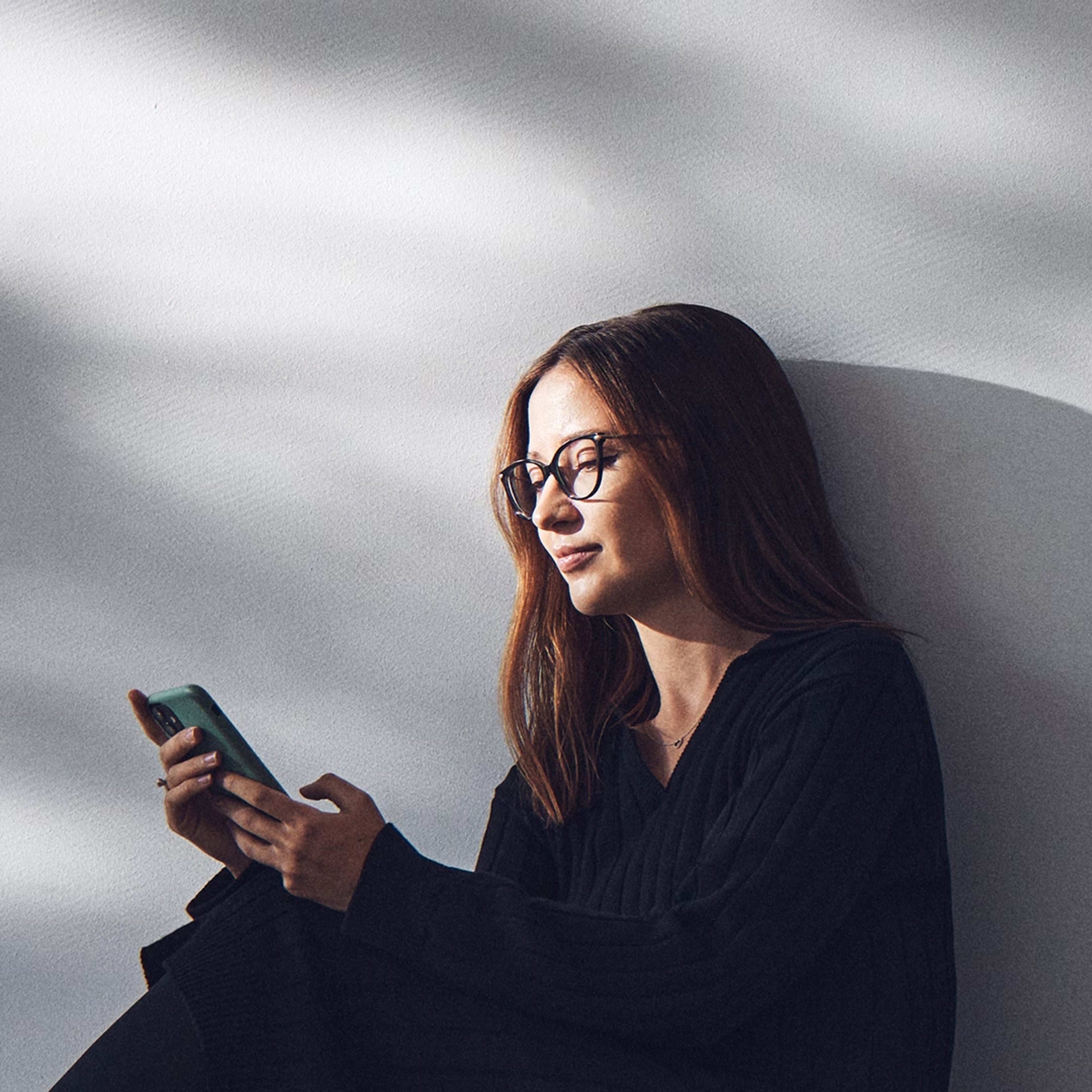 A woman uses her mobile phone to access the Volvo Cars app.