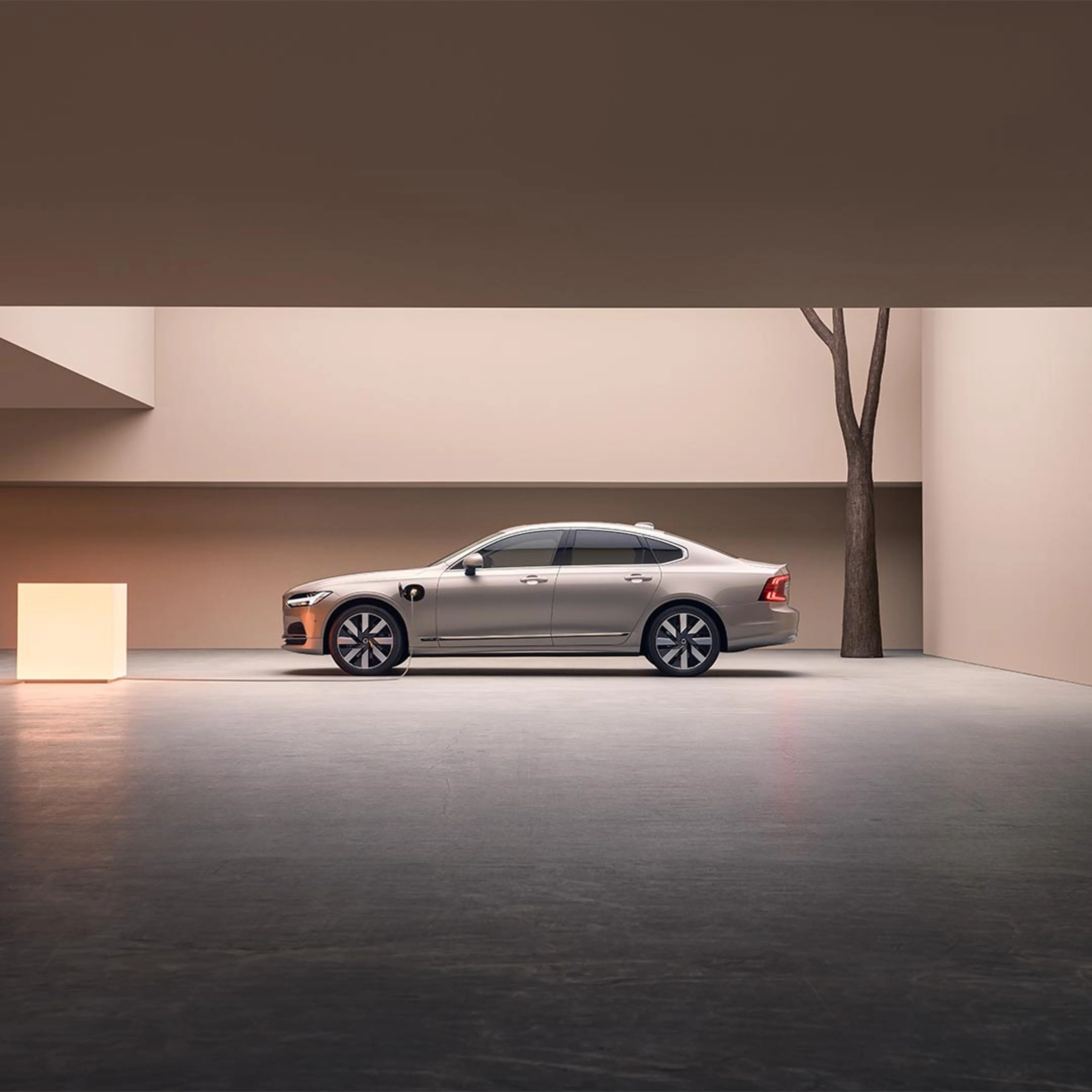 대형 콘크리트 구조물에 주차된 Volvo S90 플러그인 하이브리드 왼쪽의 광각 이미지.
