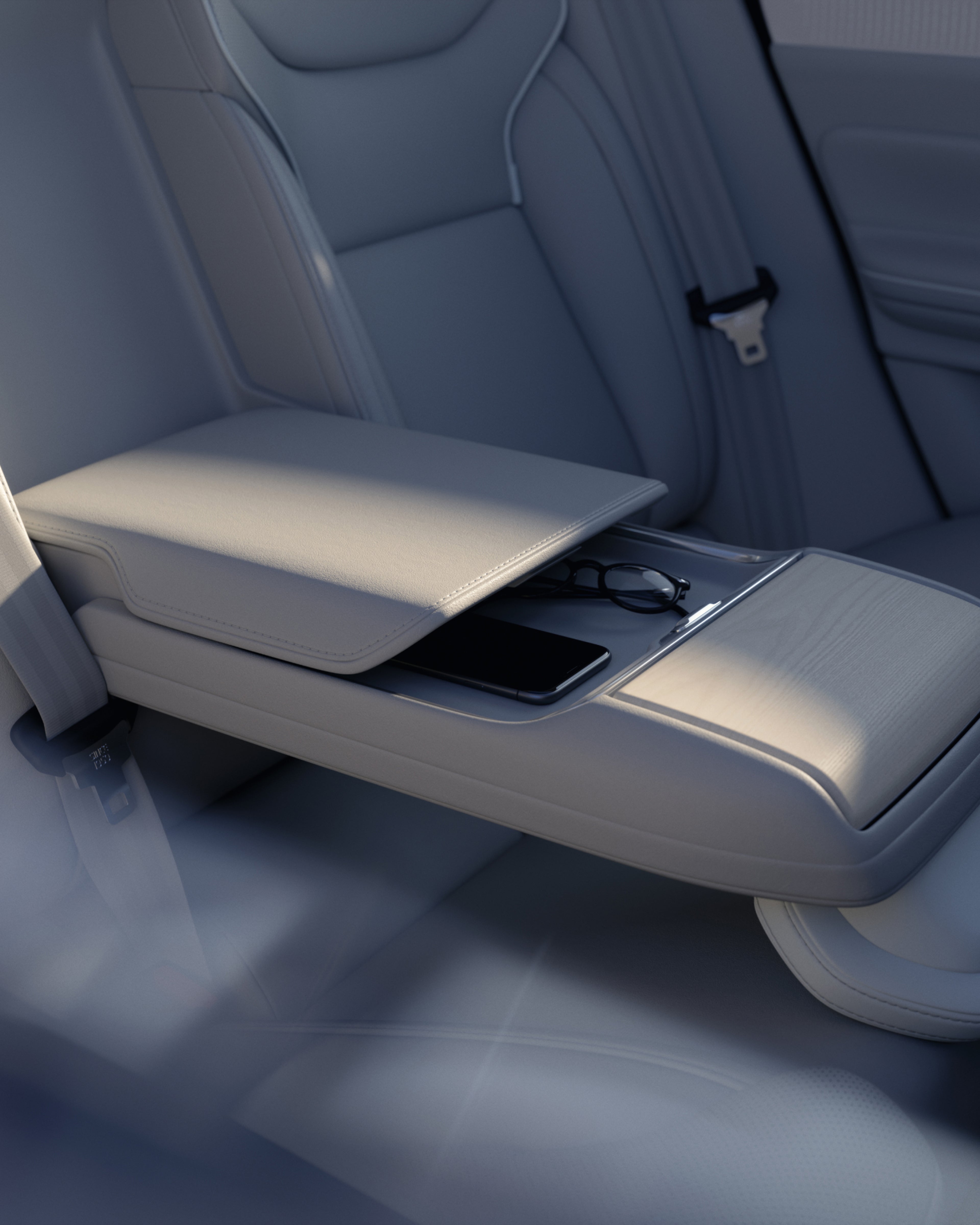 Nærbillede af Volvo ES90's bageste armlæn med et åbent opbevaringsrum med briller og en telefon.