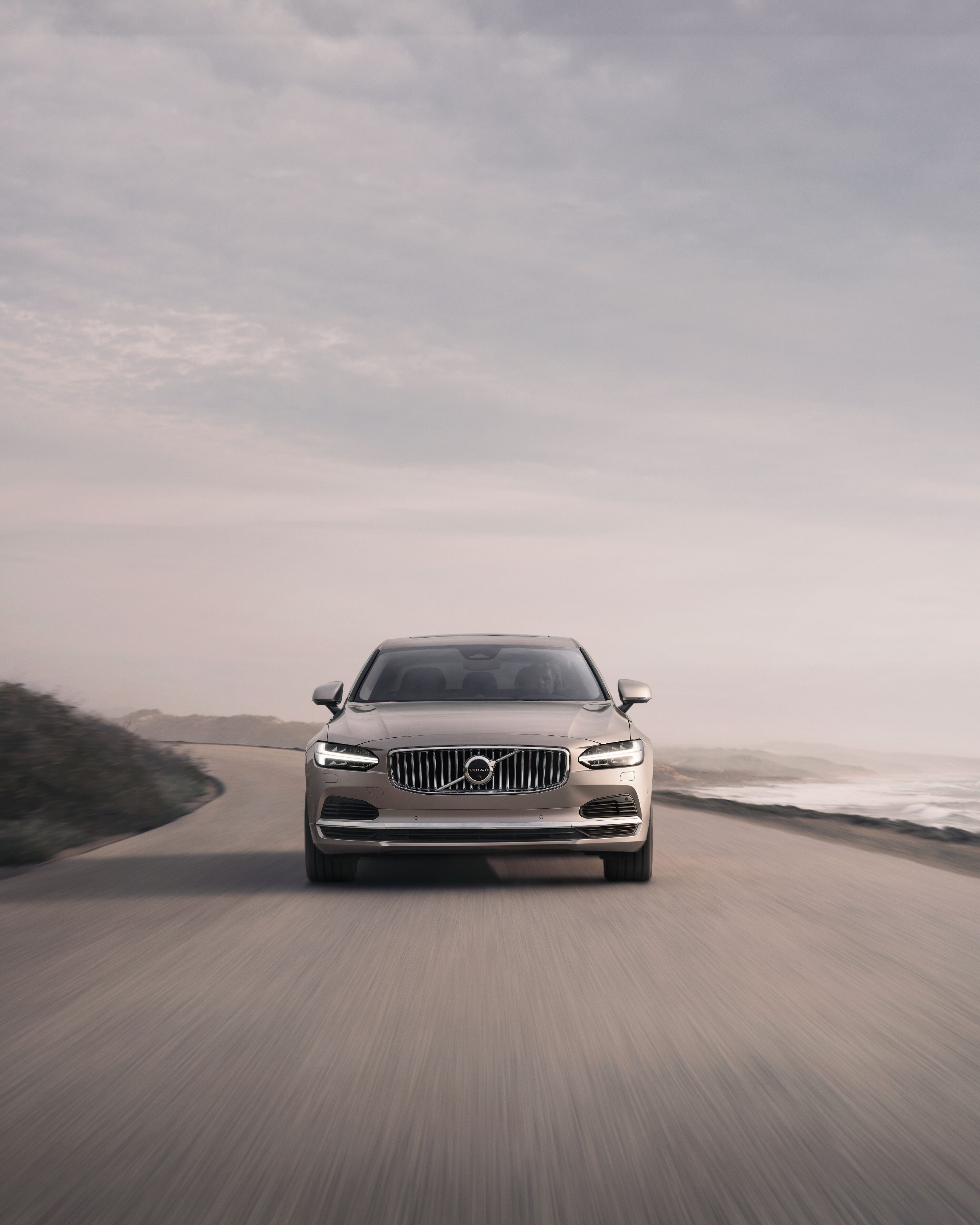 Picture of a Volvo S90 from the front while driving on a road.