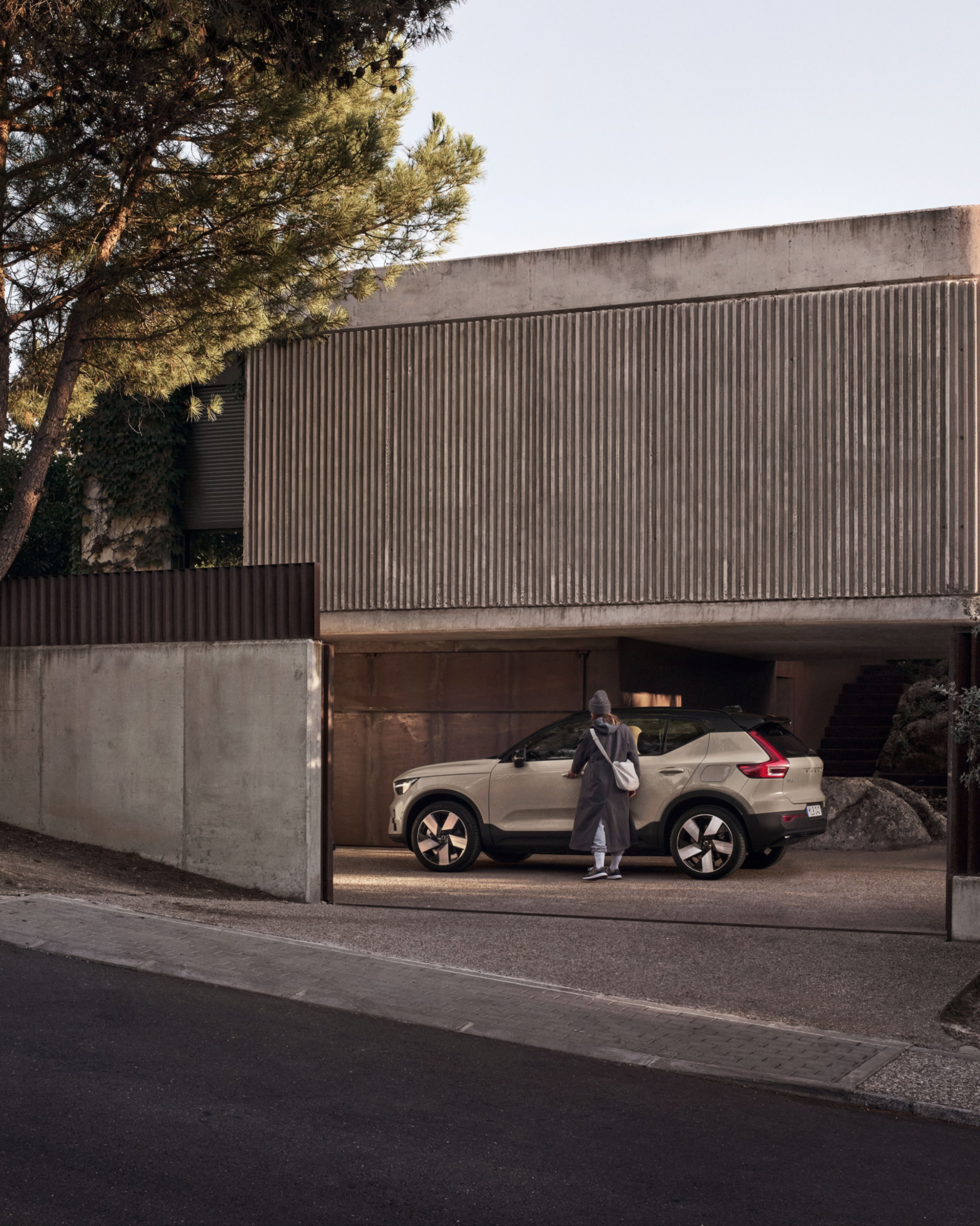 Side view of the Volvo EX40 with a woman about to open it.