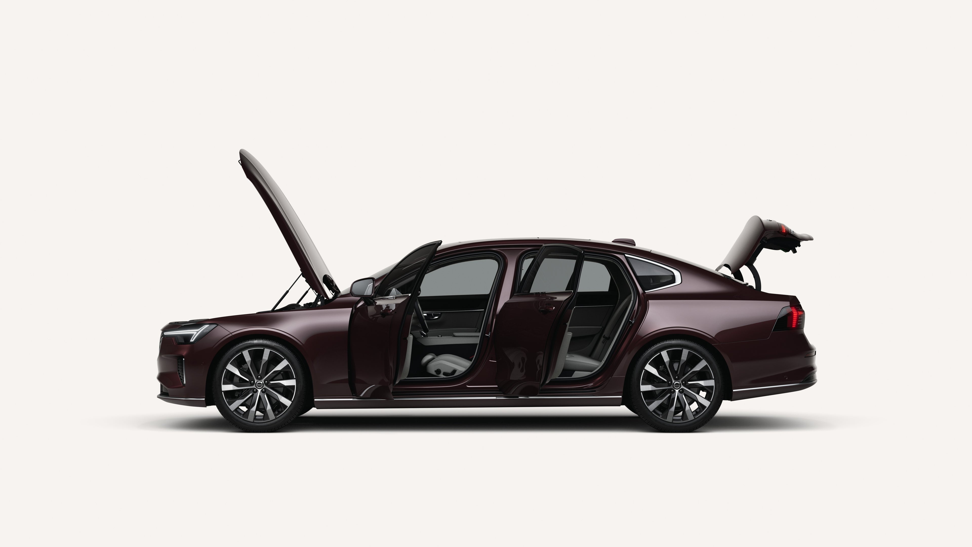 Side view of the Volvo S90 with open hood, doors, and trunk in a white studio environment.