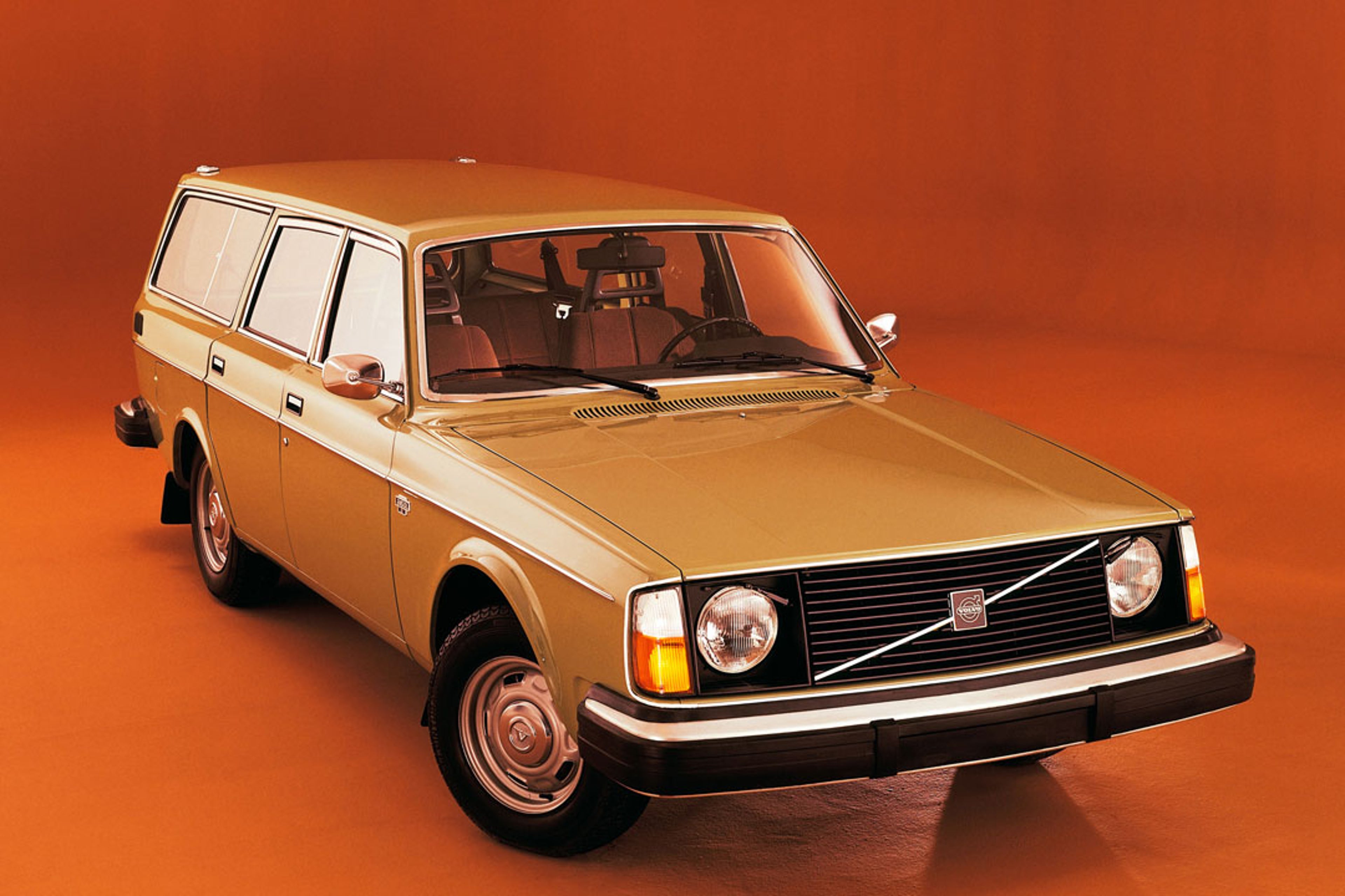 Un Volvo 245 naranja en un estudio.