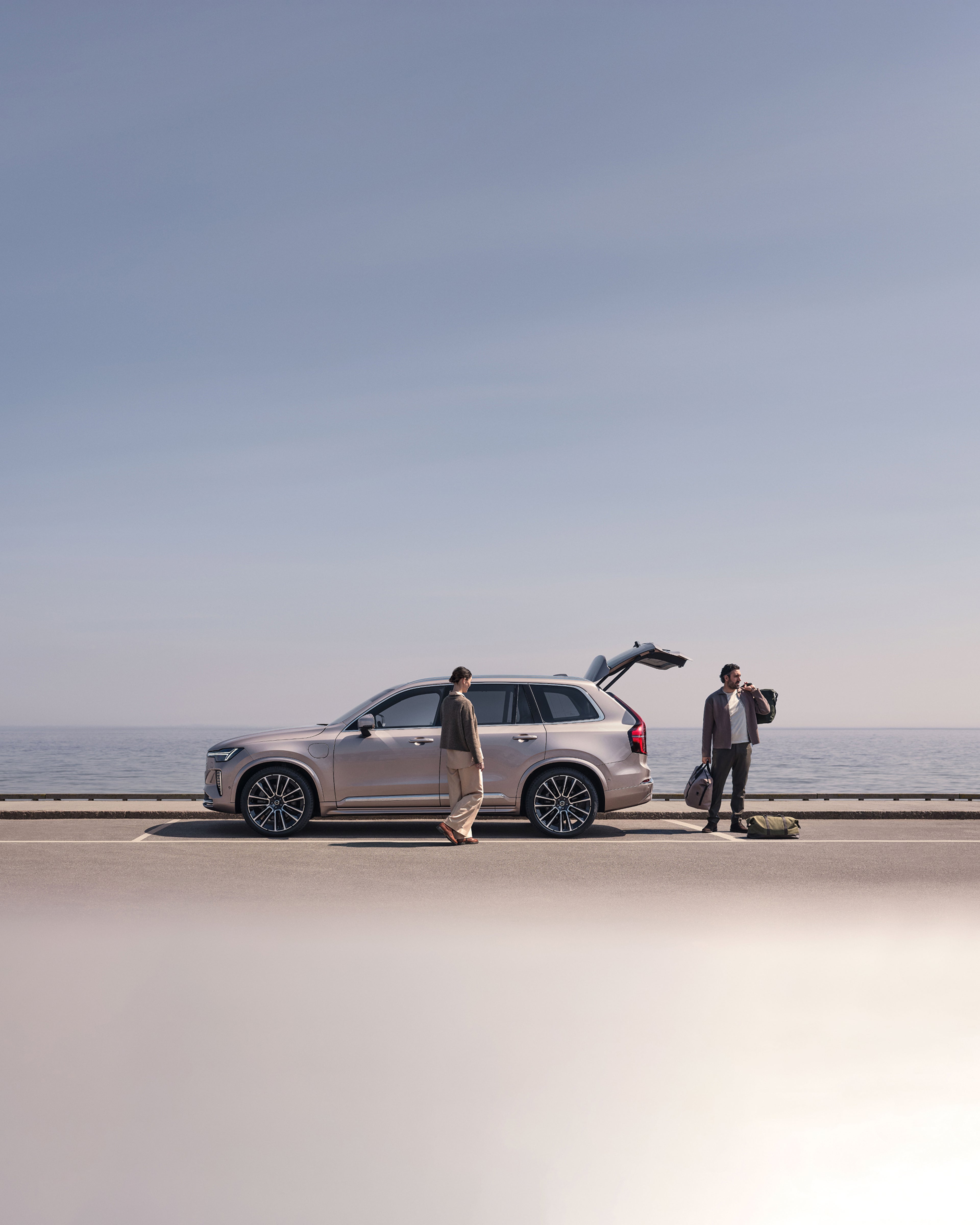 A woman and a man packing their Volvo XC90 next to the water