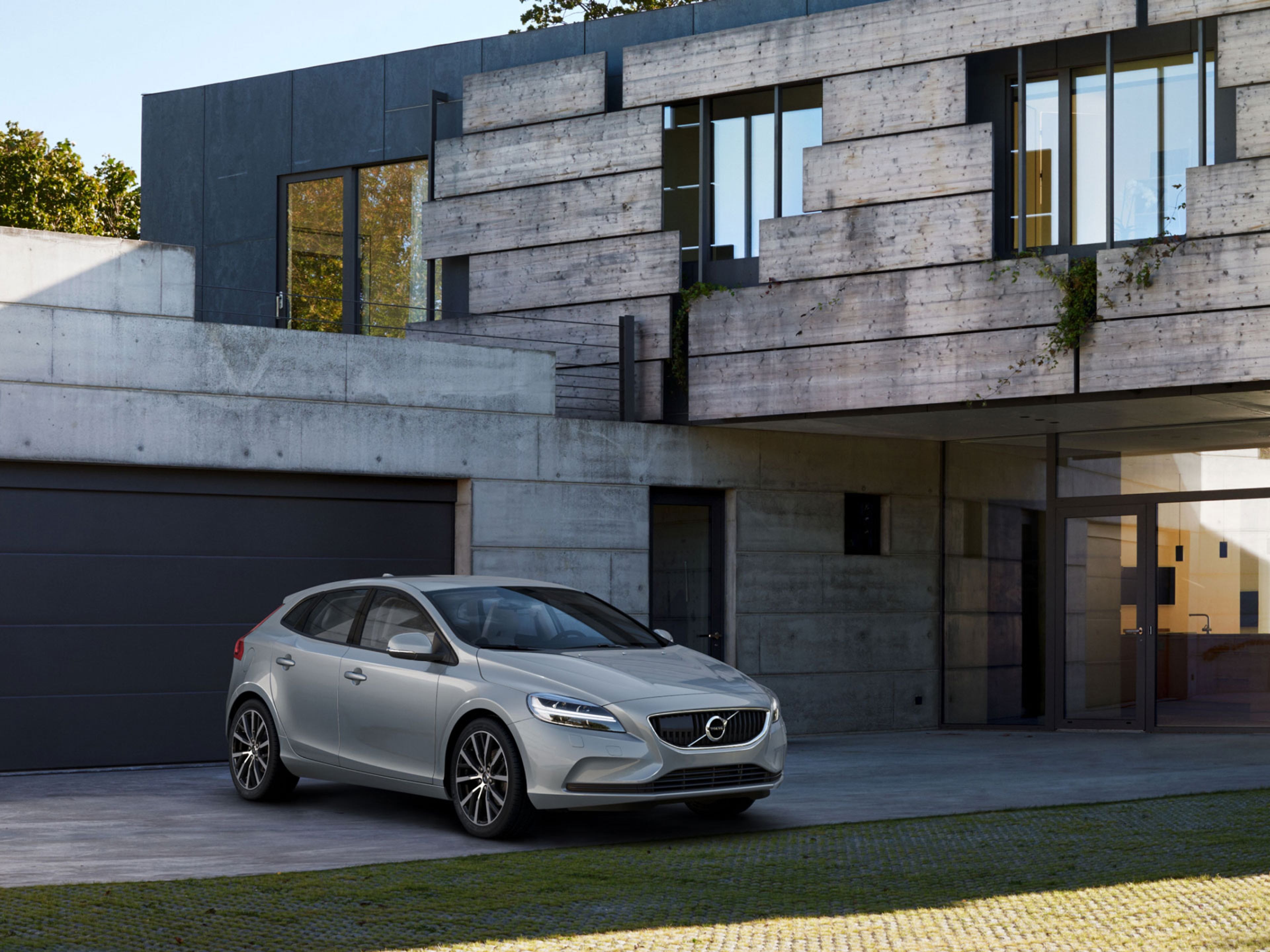 Imagen de un Volvo V40 estacionado frente a un edificio moderno.
