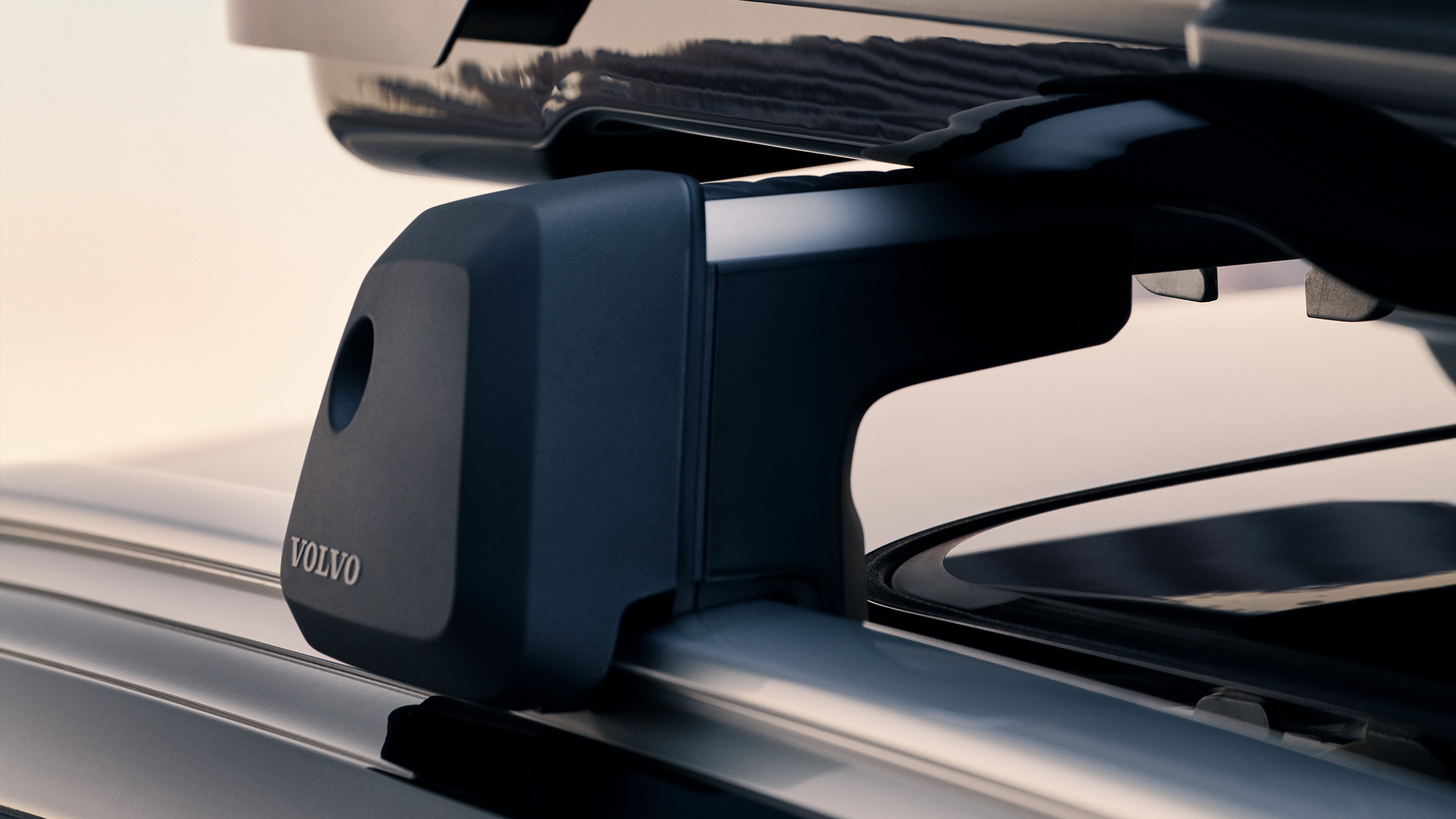 Lähikuva Volvo V60 lataushybridifarmariauton katolle kiinnitetystä taakkatelineestä ja siihen kiinnitetystä kattolaatikosta.