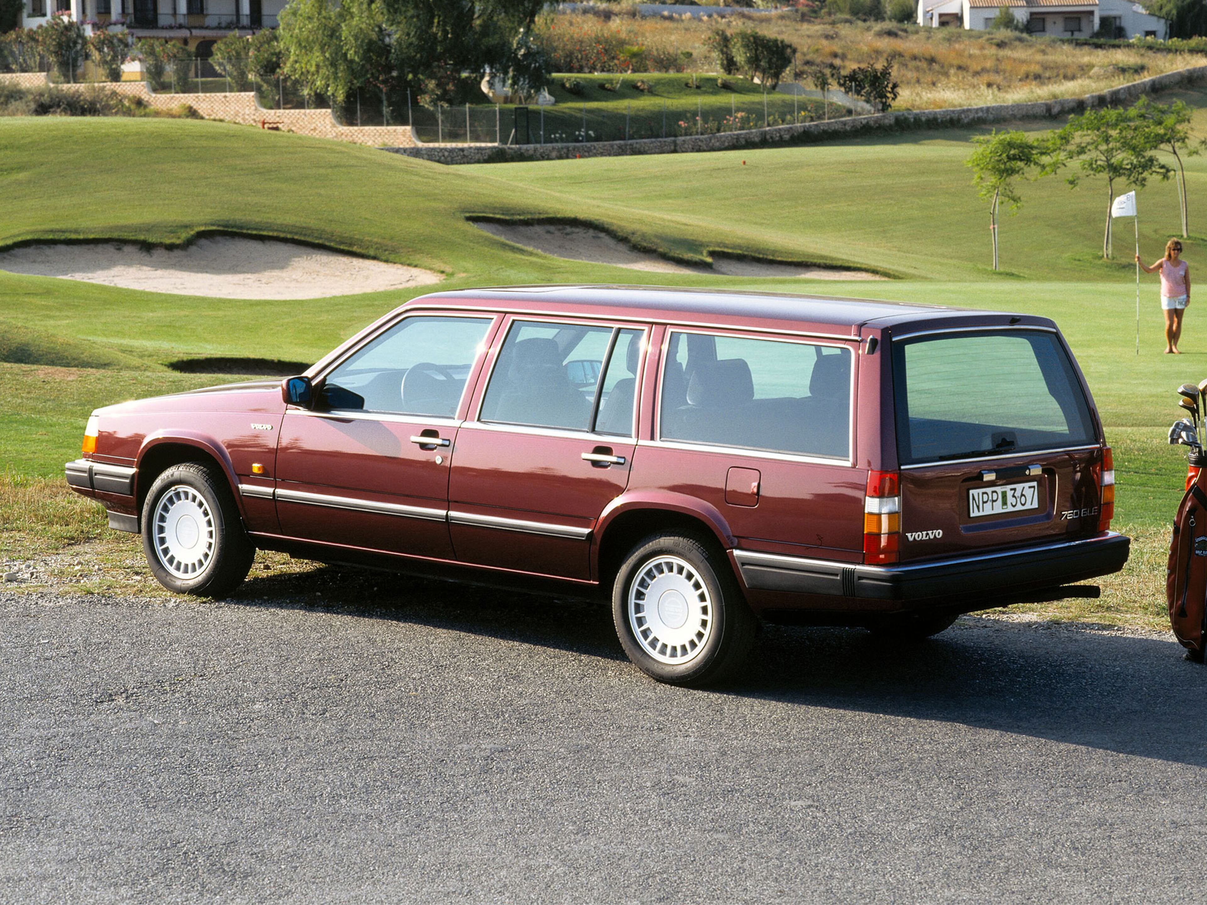 Volvo 760 Break rouge garé près d’un parcours de golf