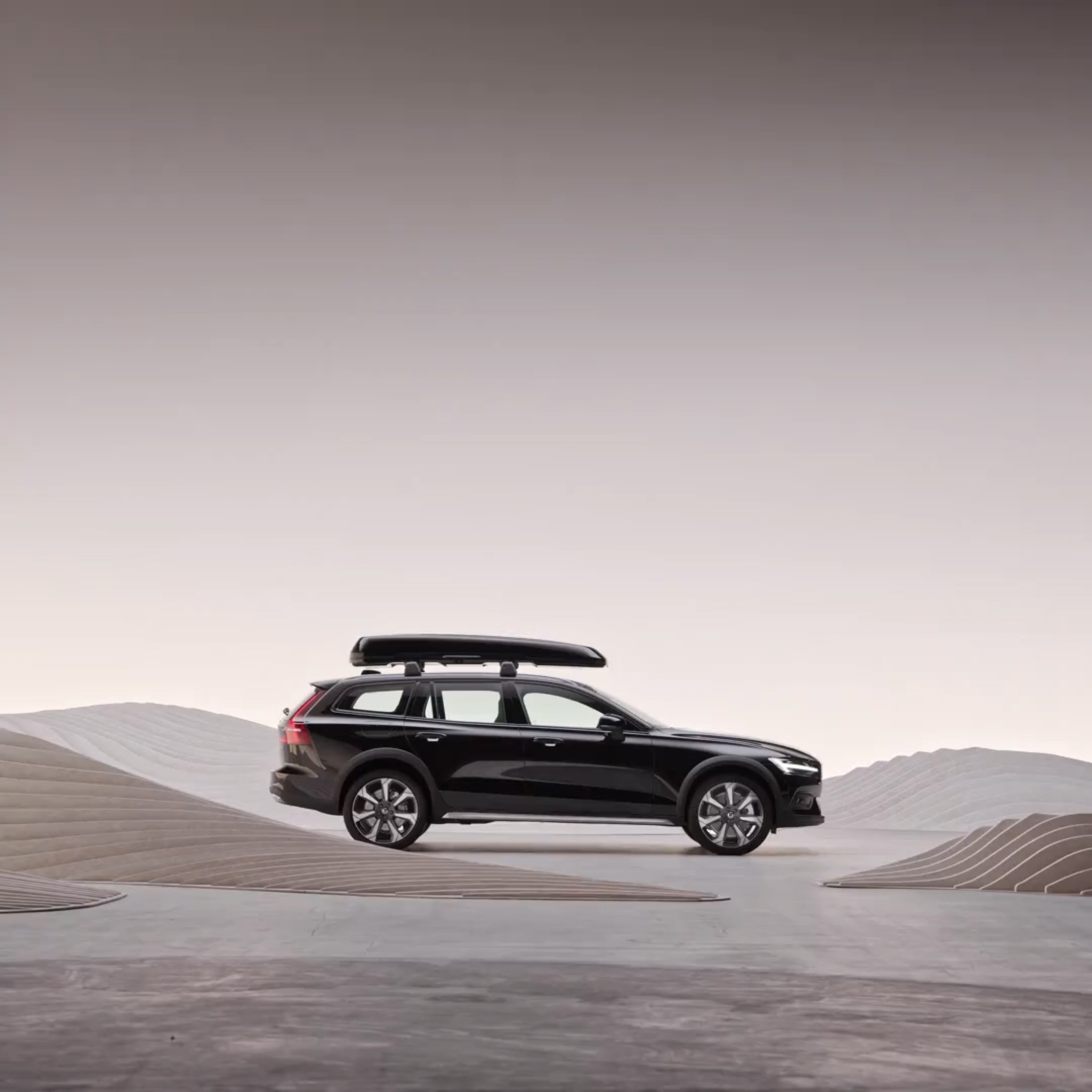 The side profile of a Volvo V60 Cross Country wagon with a roof box.