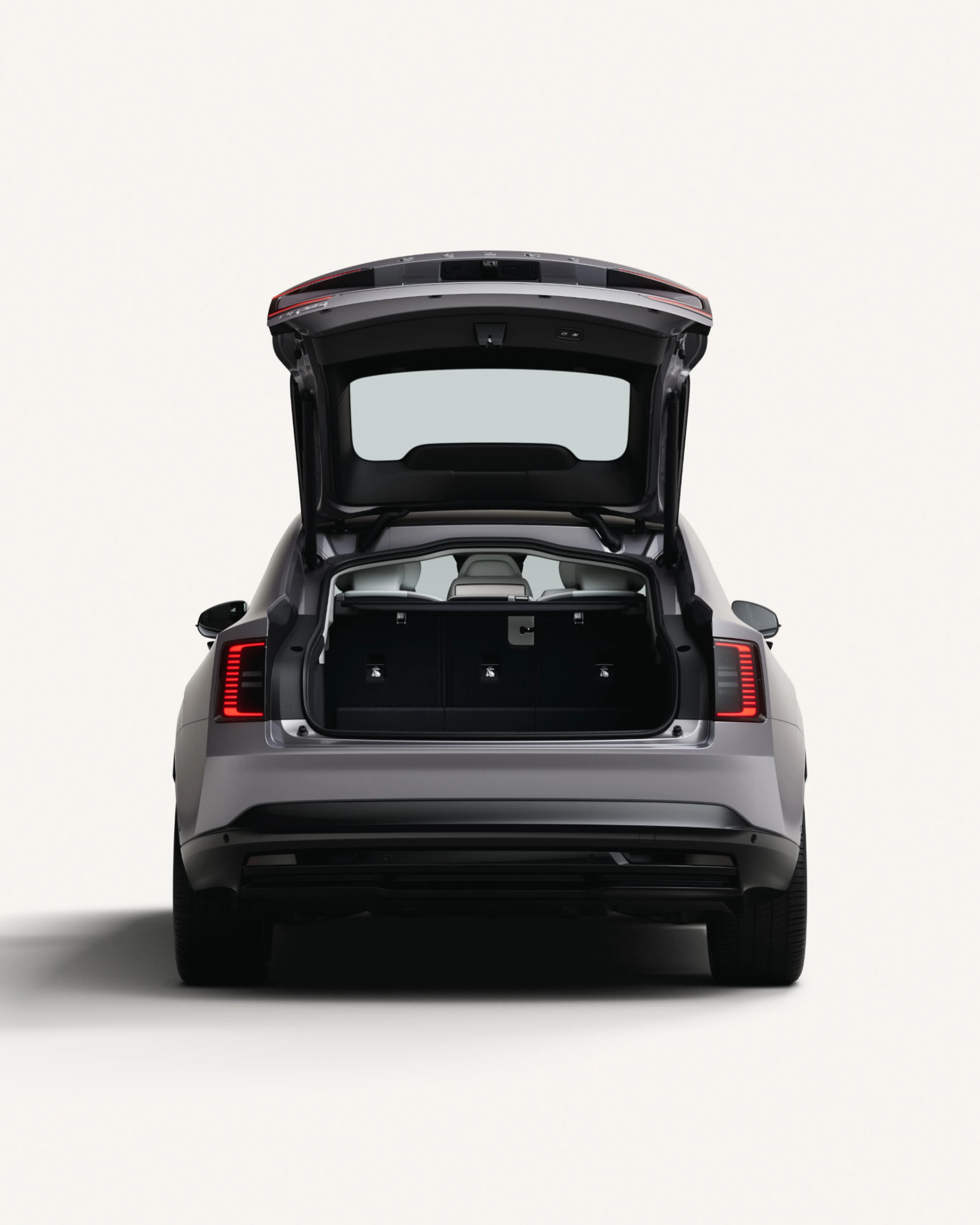 Vista posteriore di Volvo ES90 con il bagagliaio aperto che mostra l'area di carico.
