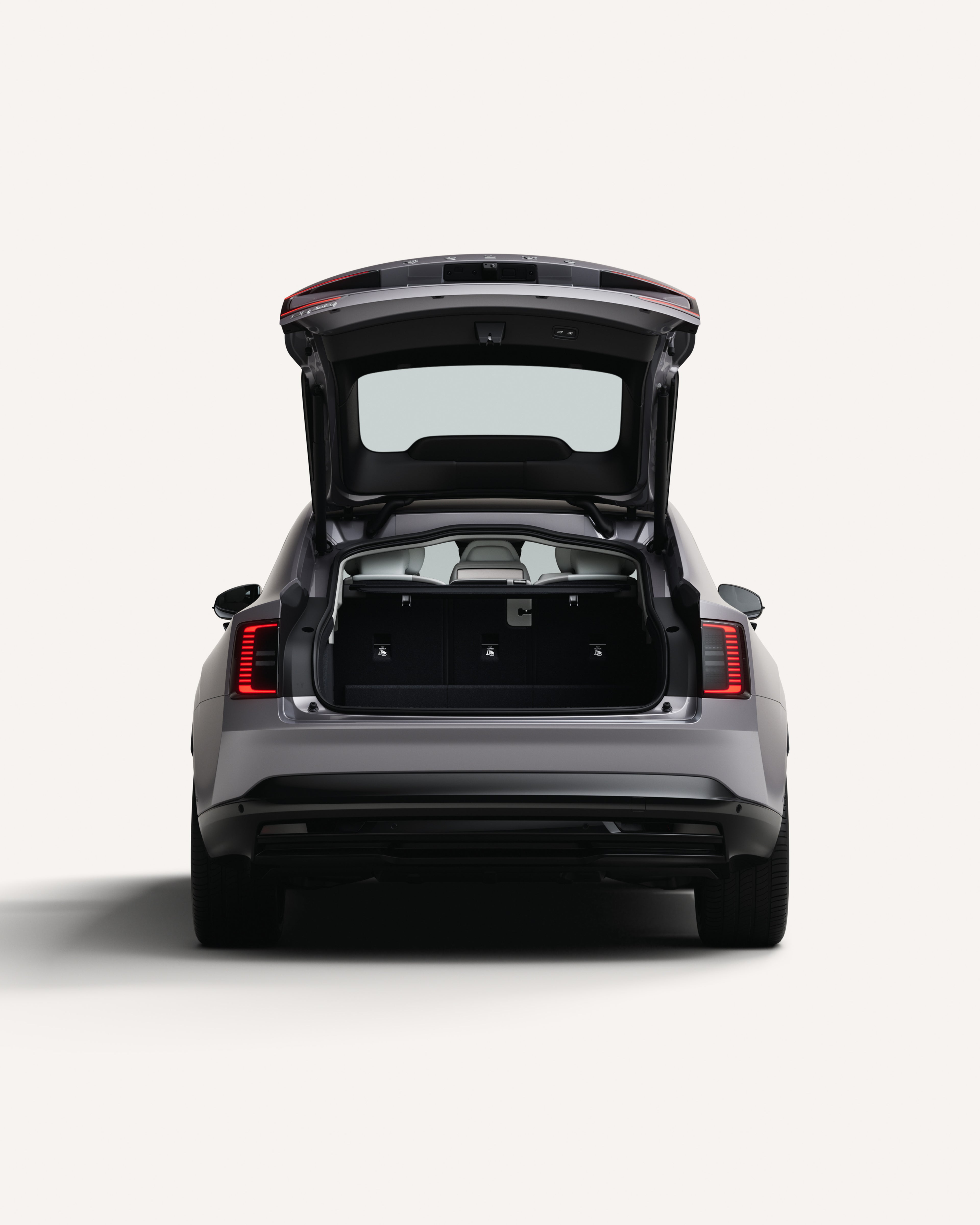 Vue arrière de la Volvo ES90 avec le coffre ouvert montrant l’espace de chargement.