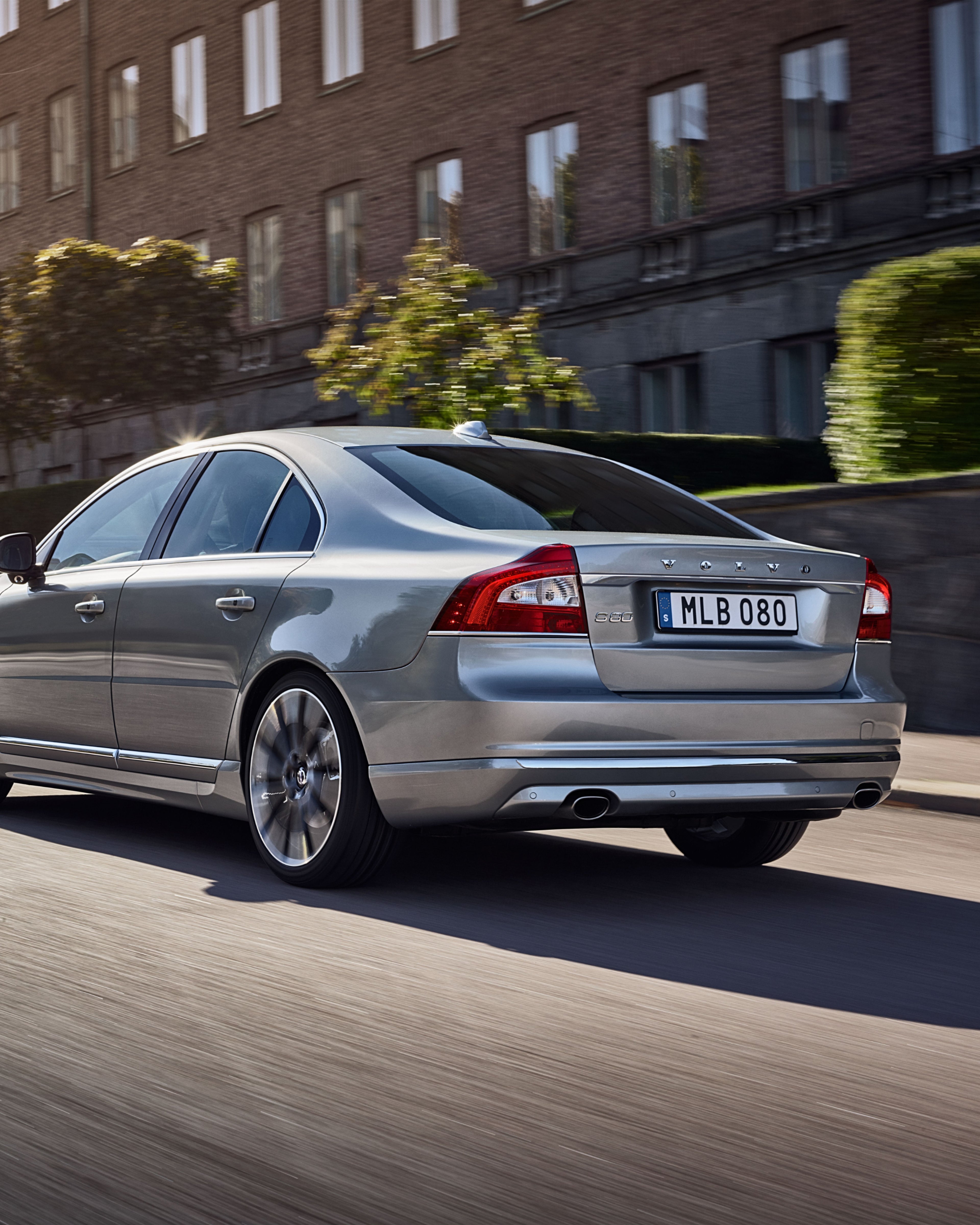 The rear of a Volvo S80 driving on a street.