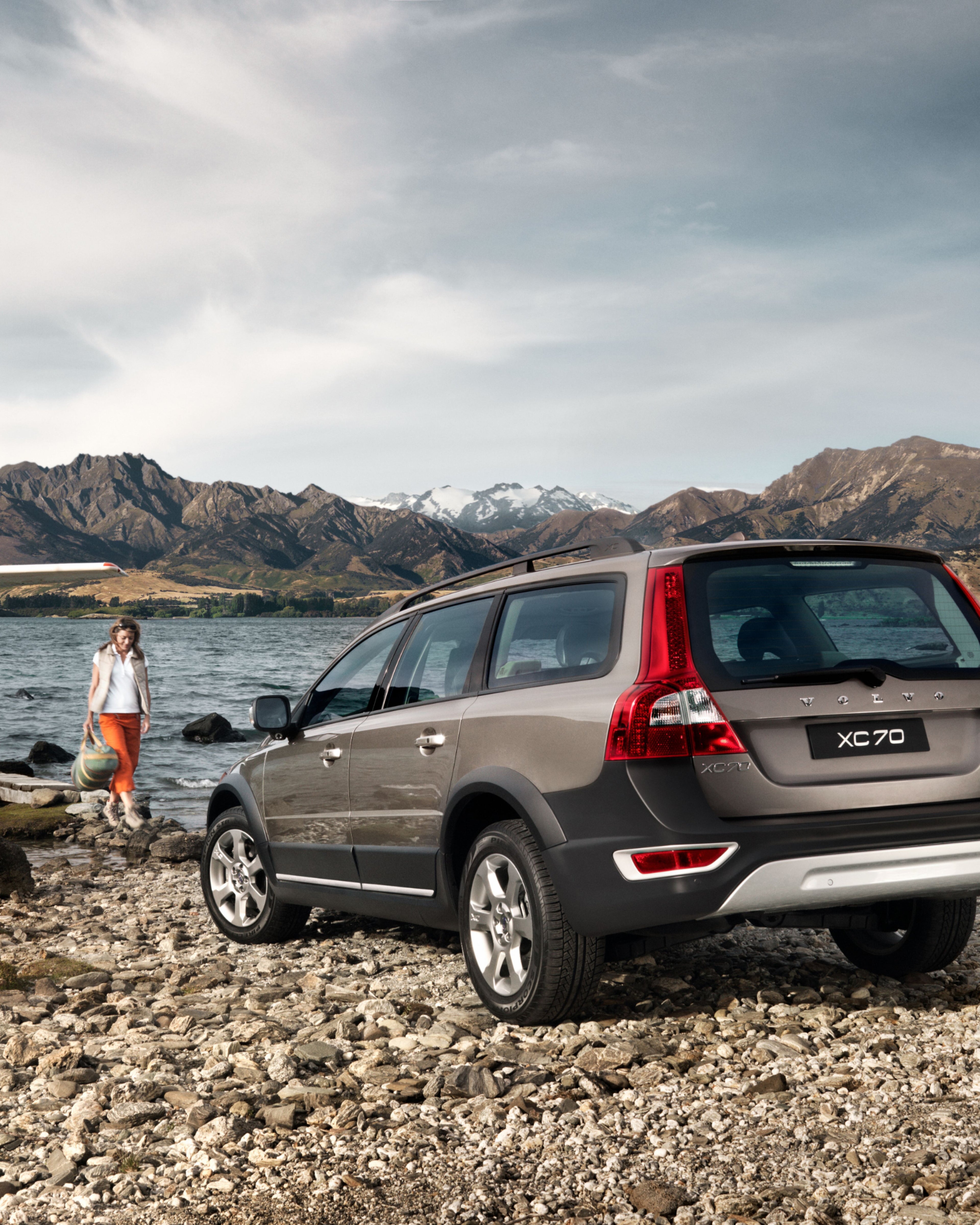 Imagen de un Volvo XC70 estacionado en la orilla junto a un lago.