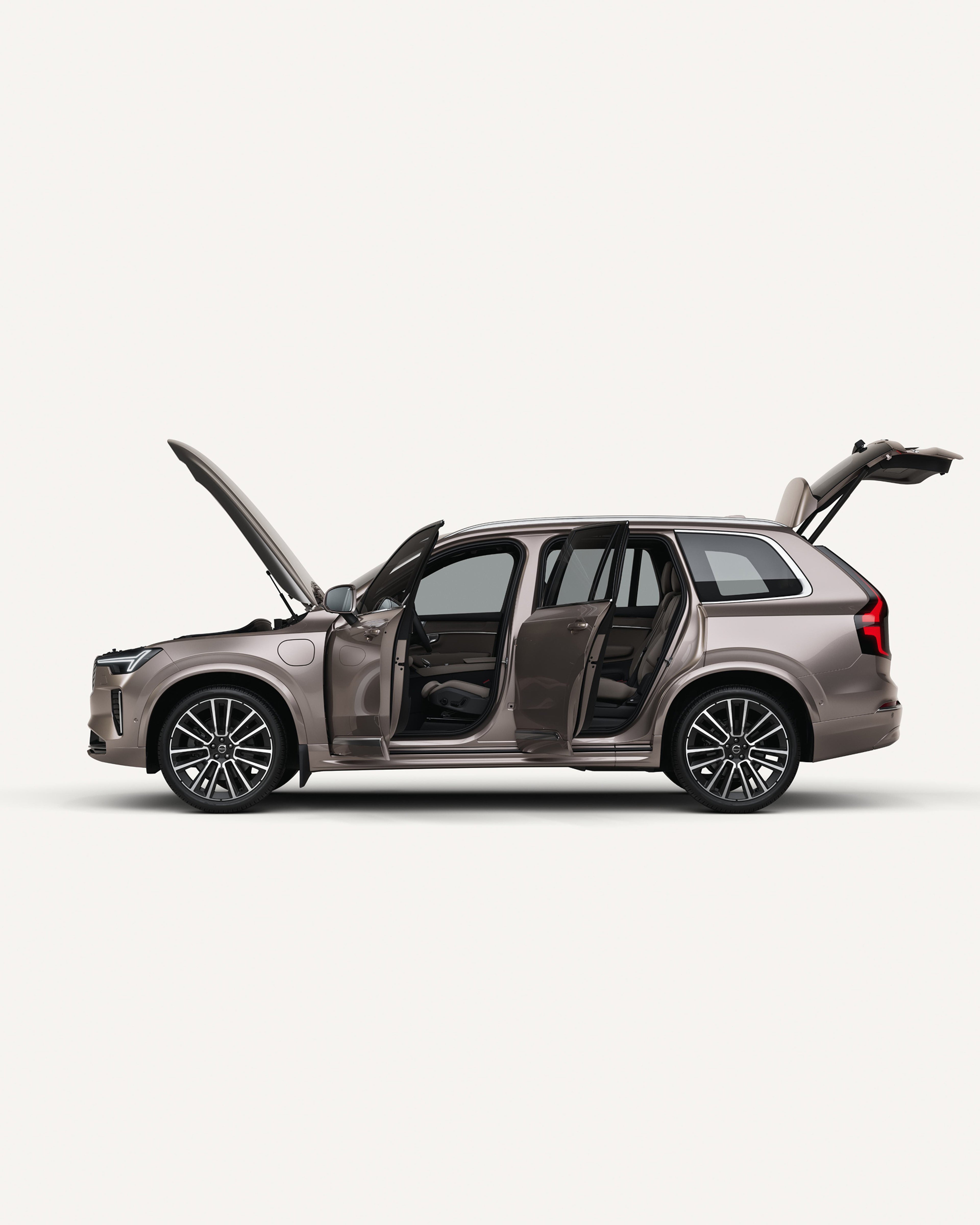 Vista lateral del Volvo XC90 con el capó, las puertas y el maletero abiertos en un estudio blanco.