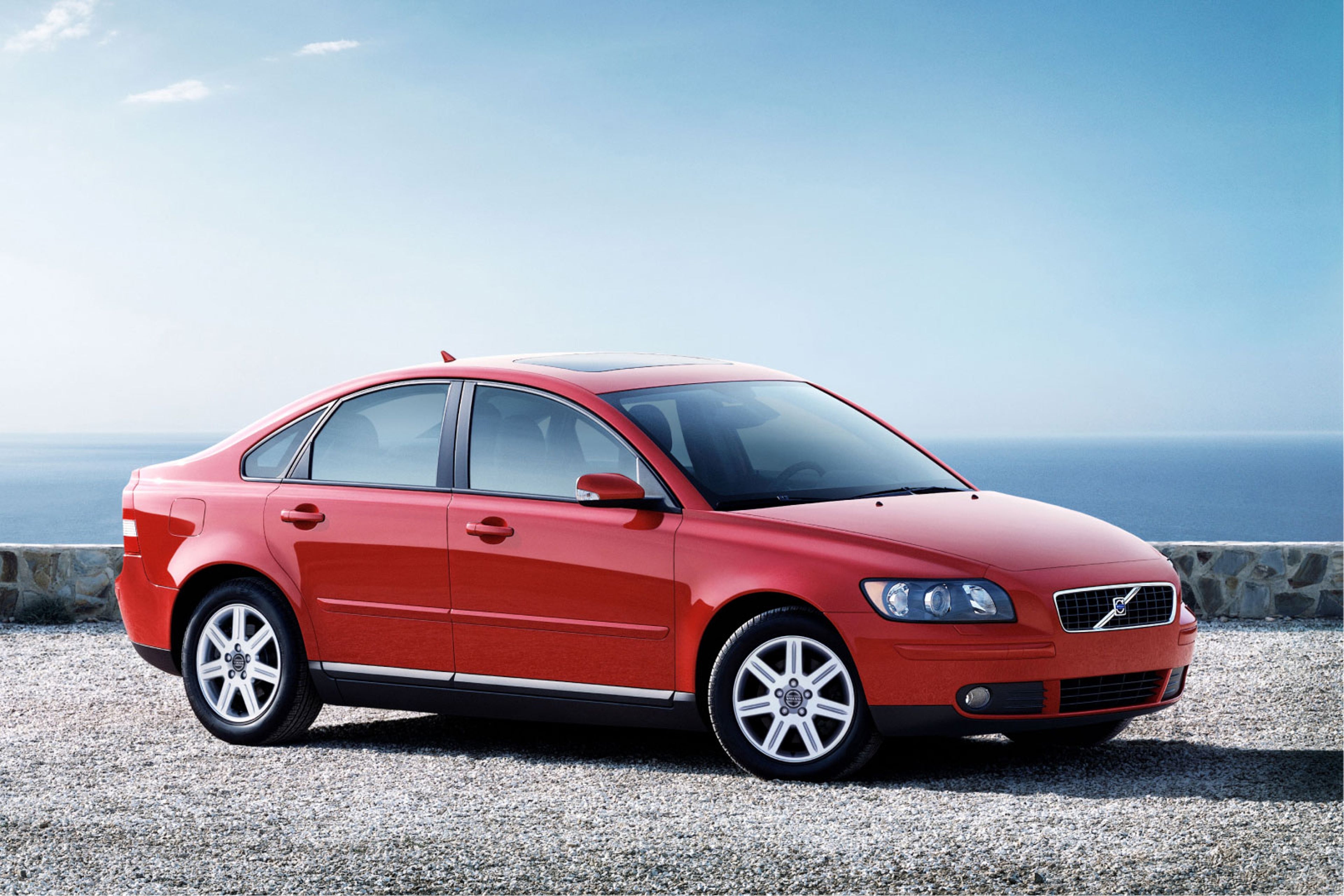 Imagen de un Volvo S40 gris visto desde atrás en ángulo, aparcado junto a un edificio.