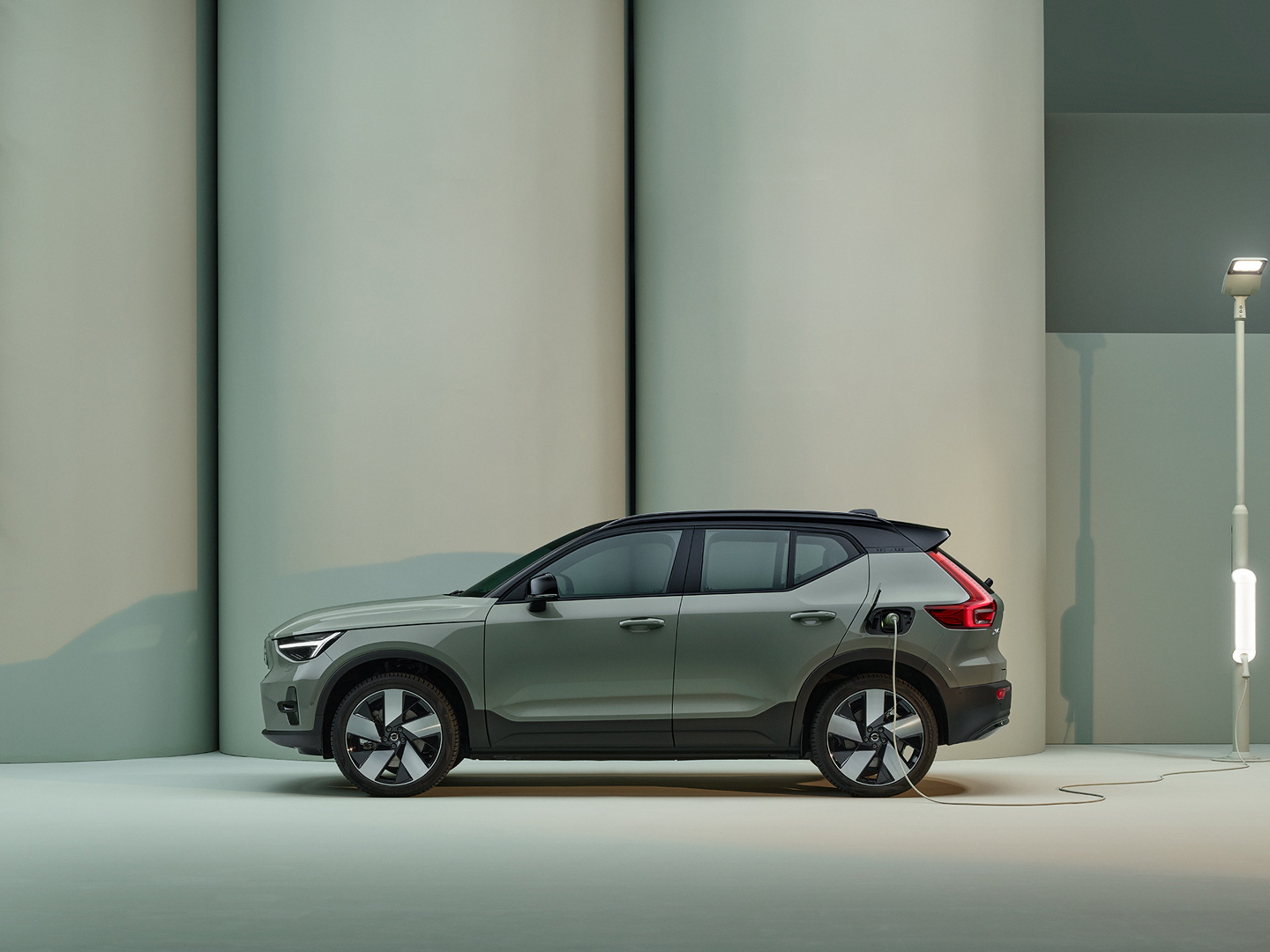 The side profile of a green Volvo XC40 Recharge pure electric SUV.