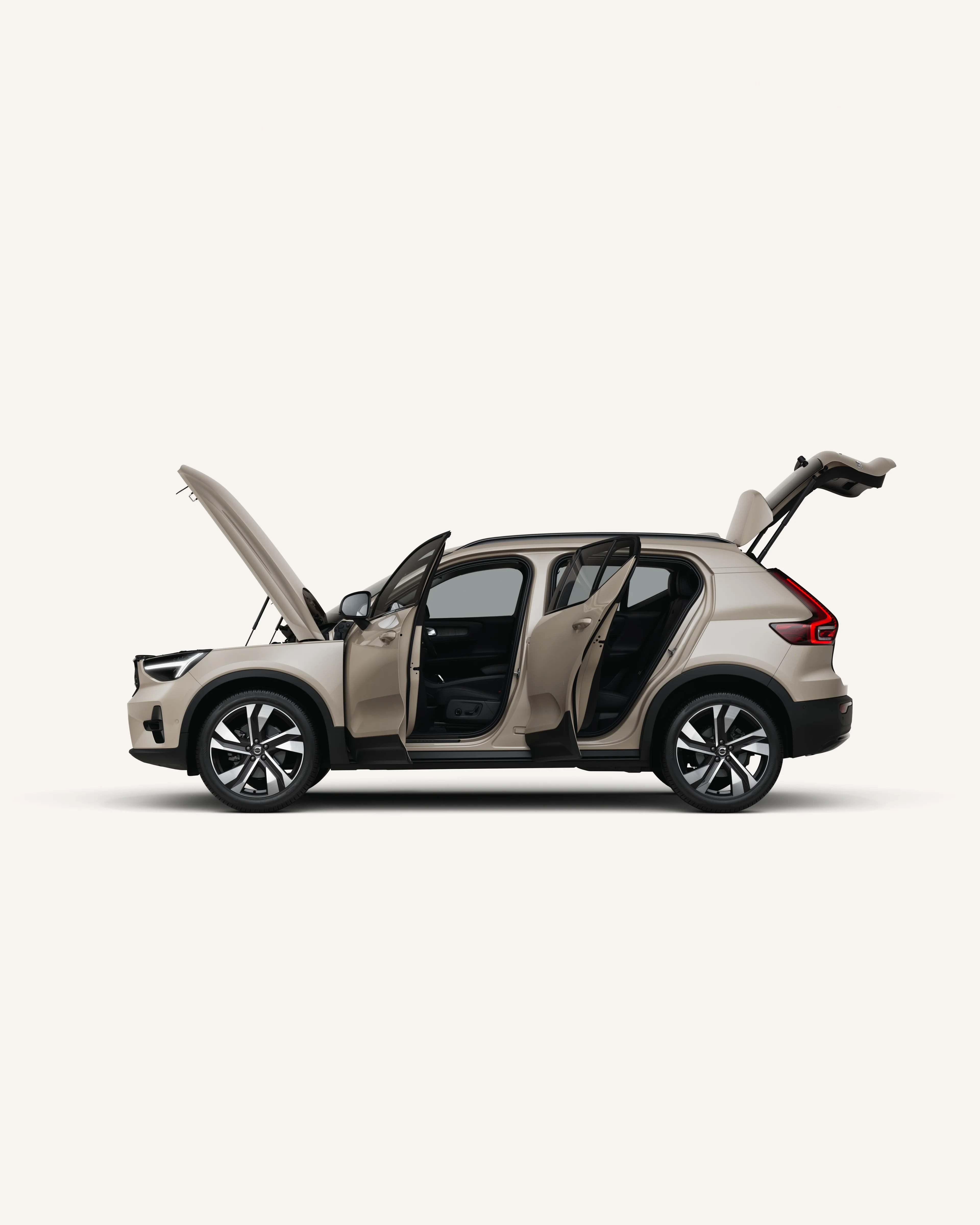 Widok z boku na Volvo XC40 z otwartą maską, drzwiami i bagażnikiem w białym studiu.