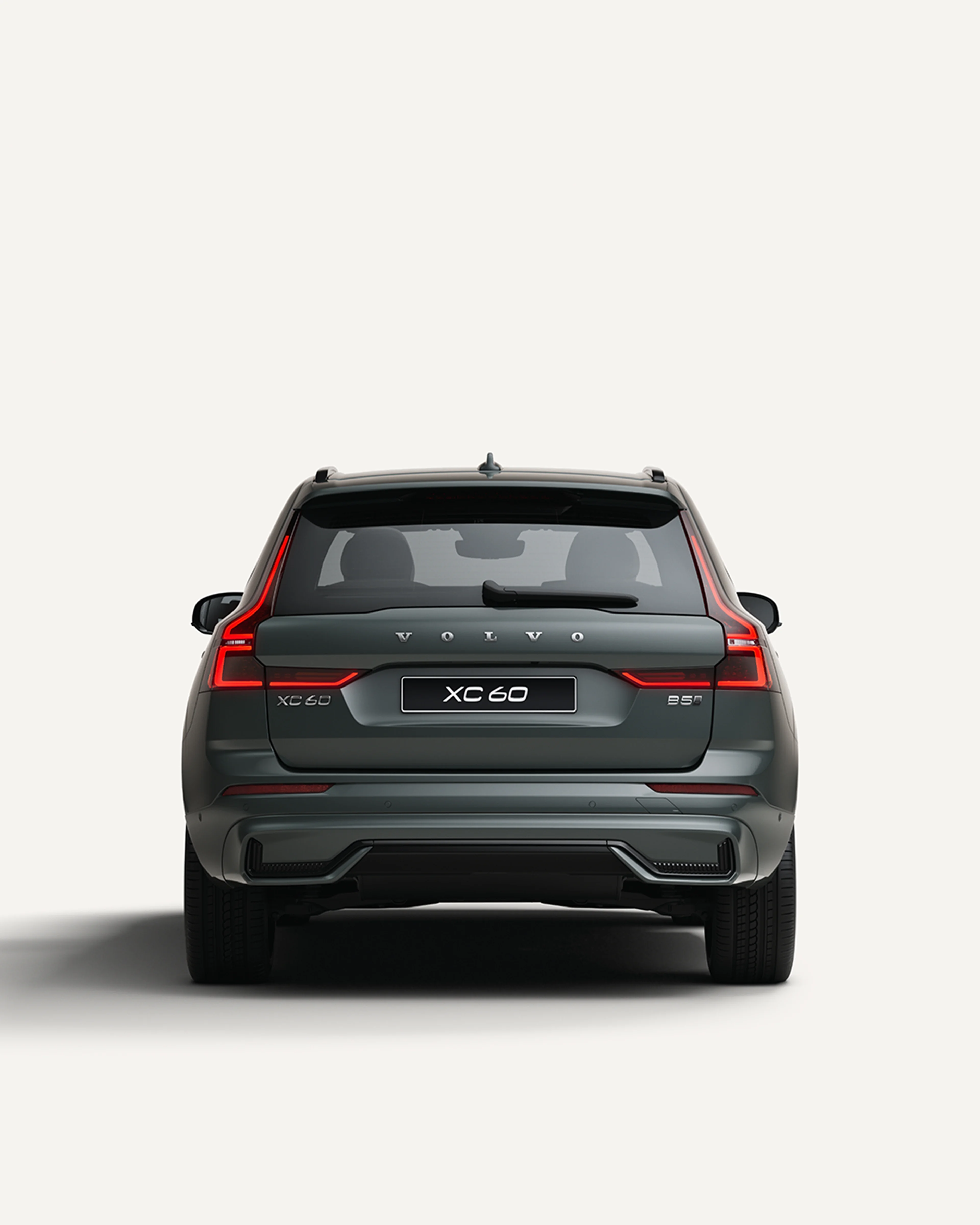 Rear view of the Volvo XC60 midsize mild-hybrid SUV in a white studio environment.