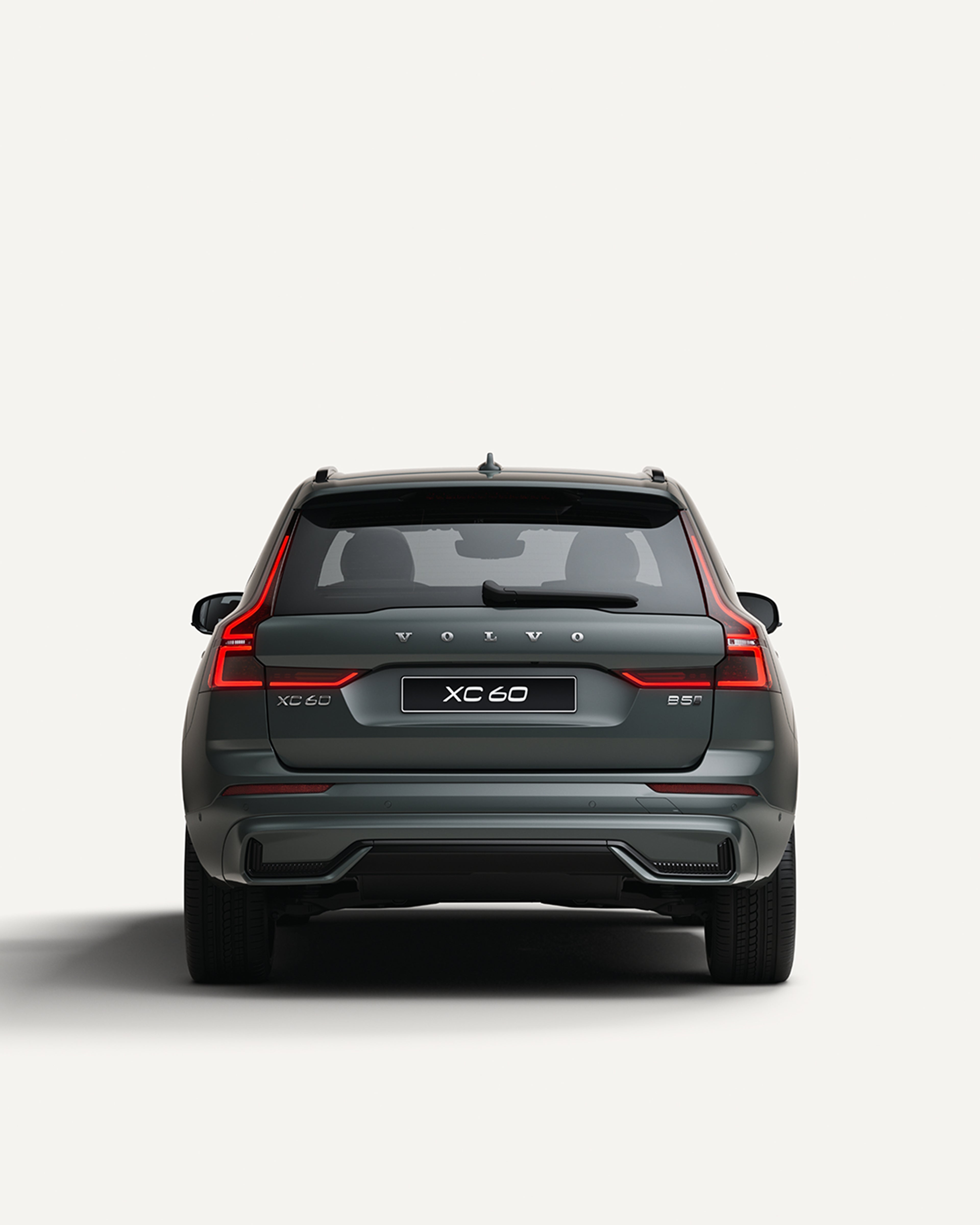 Πίσω όψη του μεσαίου ήπιου υβριδικού SUV Volvo XC60 σε λευκό περιβάλλον στούντιο.