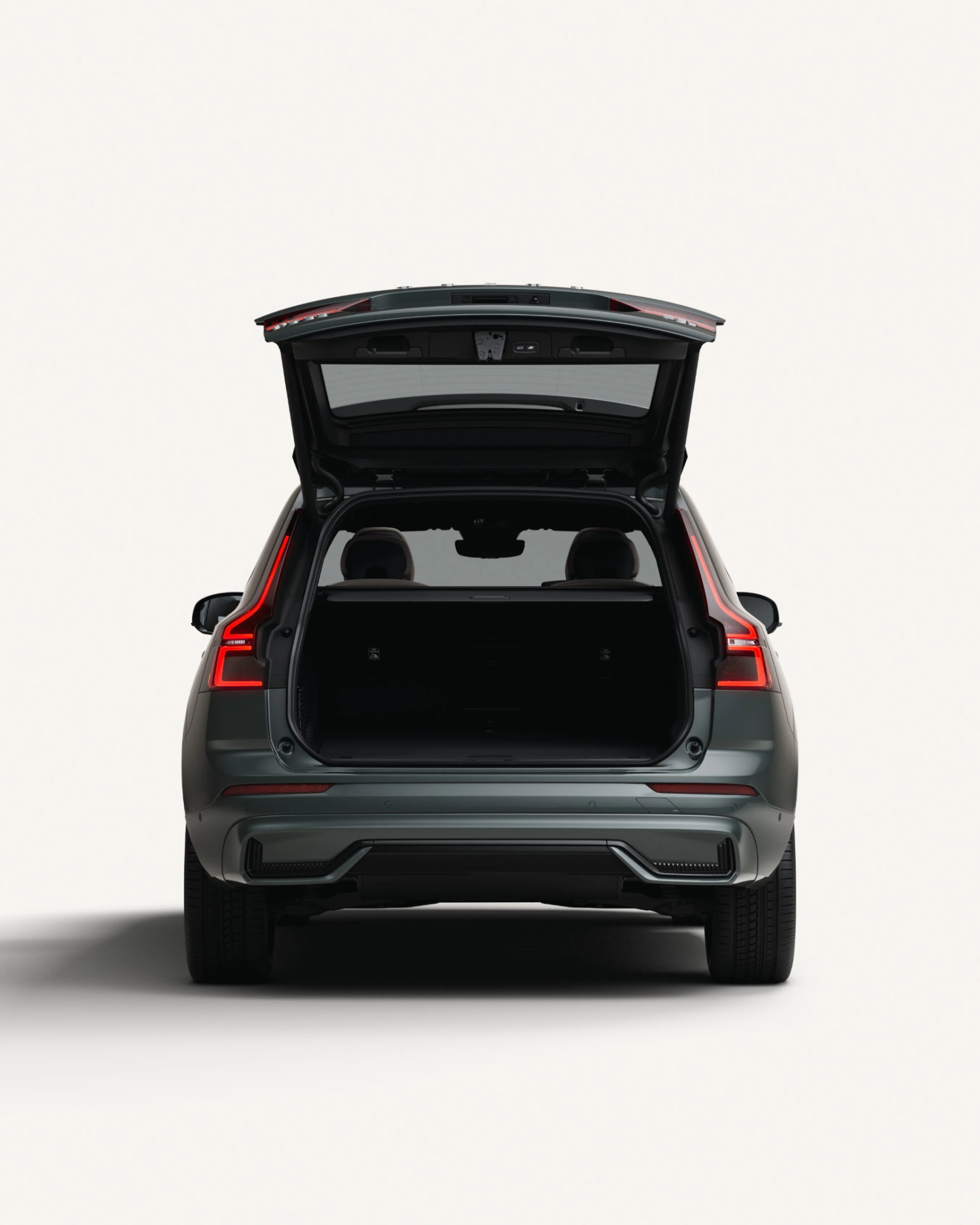 The open rear load compartment the Volvo XC60 midsize plug-in hybrid SUV in a white studio environment.